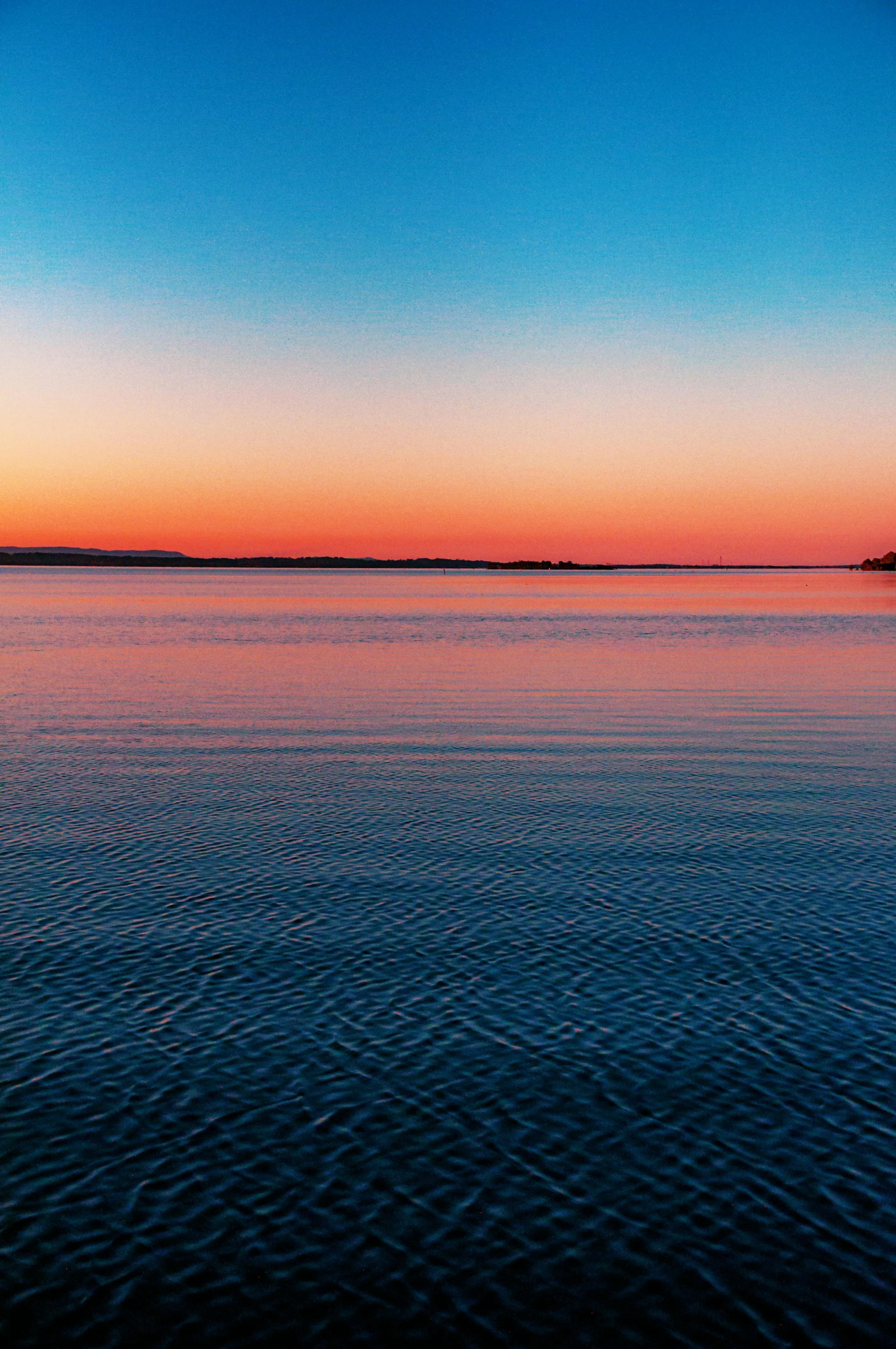 Tranquil Ocean View at Sunset with Calm Water and Clear Sky