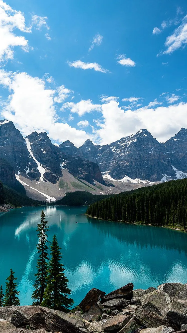 Turquoise Lake Surrounded By Pine Trees and Mountains