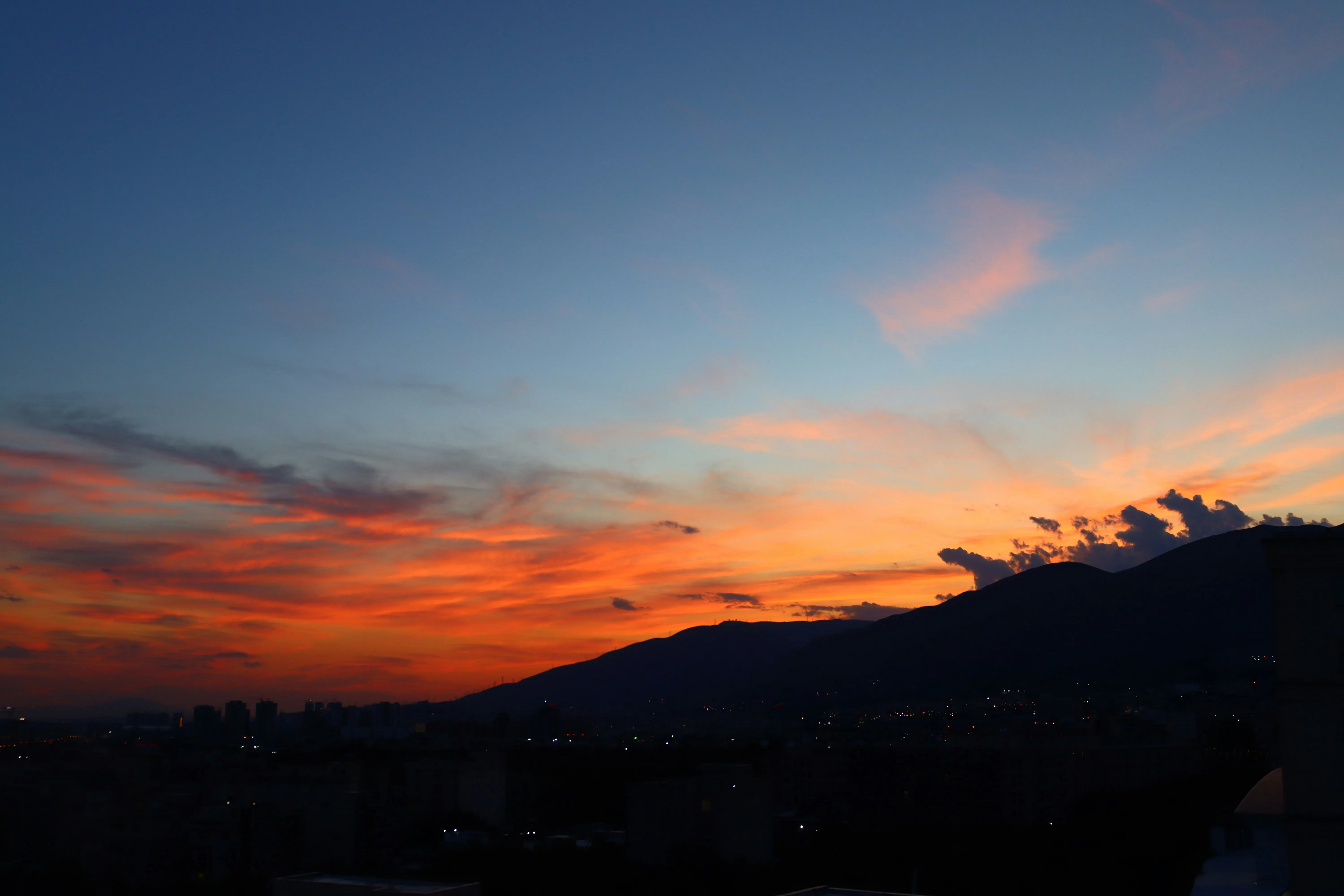 Twilight Sky with Red Clouds Fading Into Mountain Silhouette