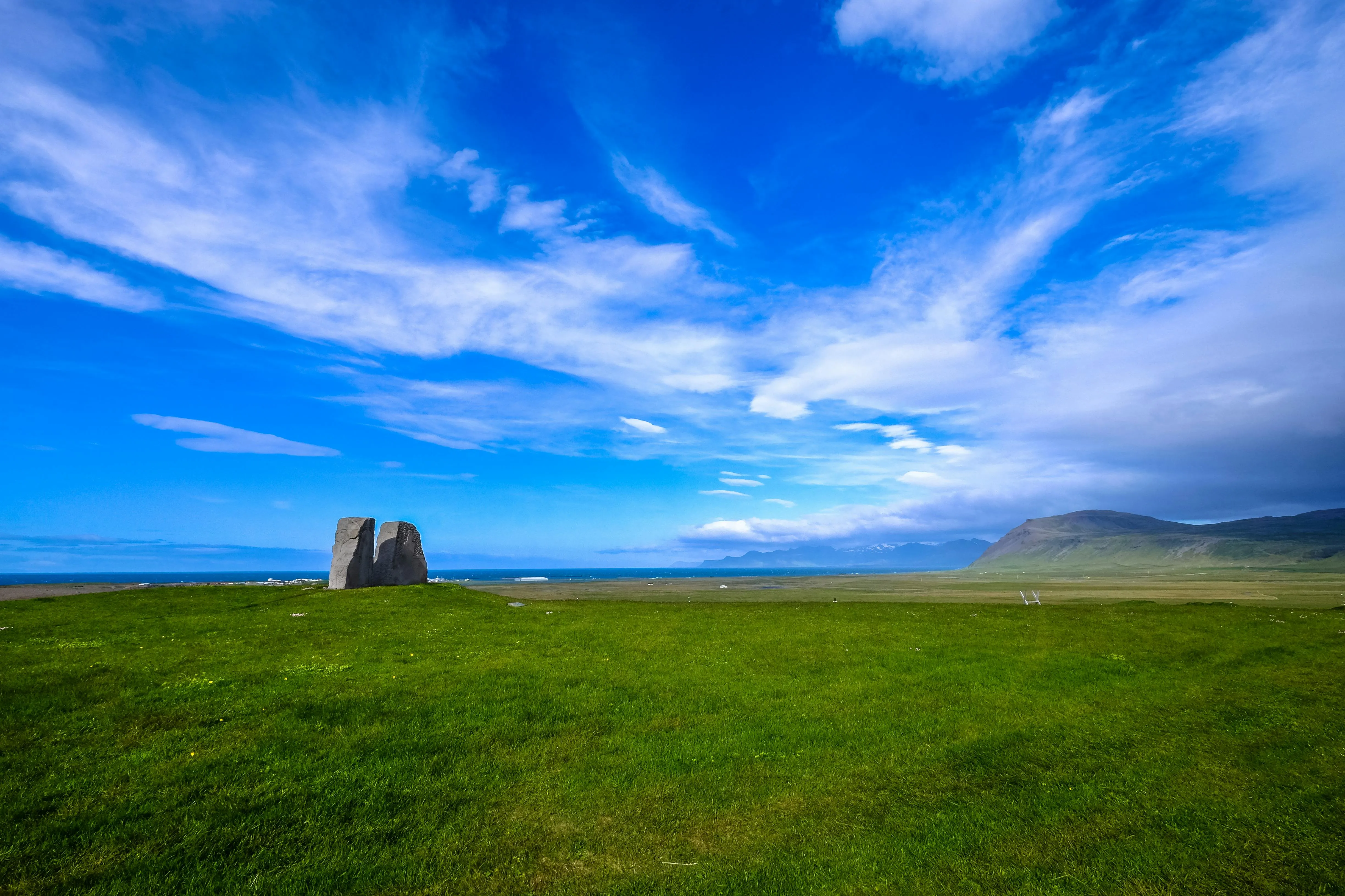 Vast Blue Sky with Cloud Waves Above a Single Haystack