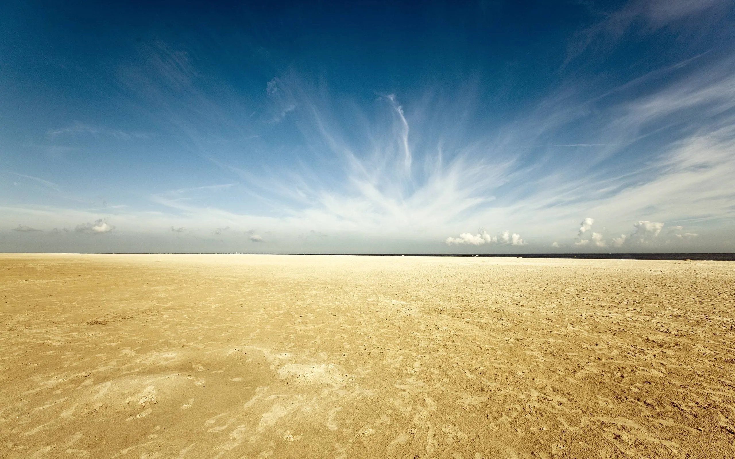 Vast Desert Landscape Under Blue Sky with Clouds Image
