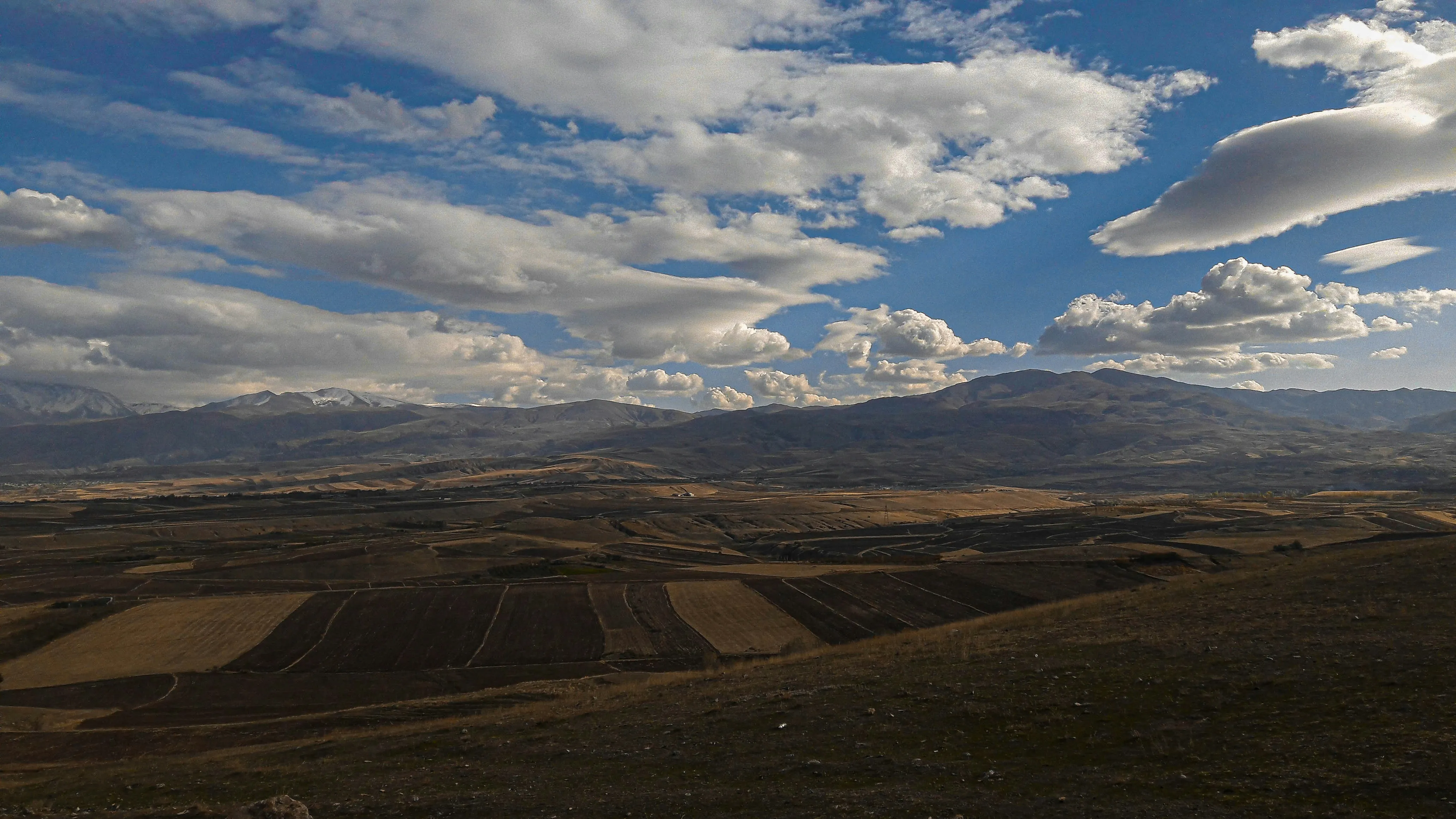 Vast Landscape with Rolling Hills and Blue Sky Wallpaper