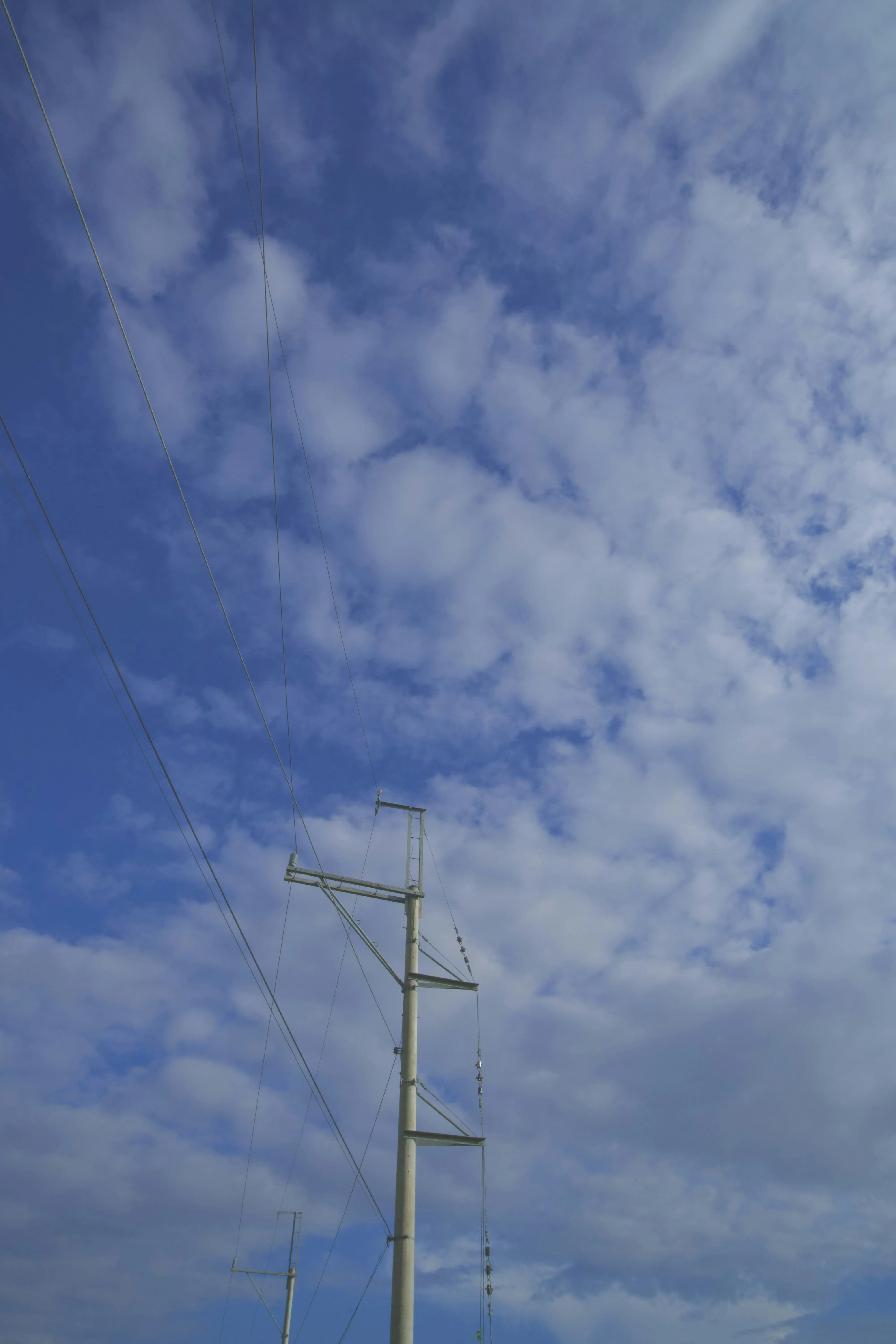 Vertical View of Electric Pole with Soft Cloudy Sky