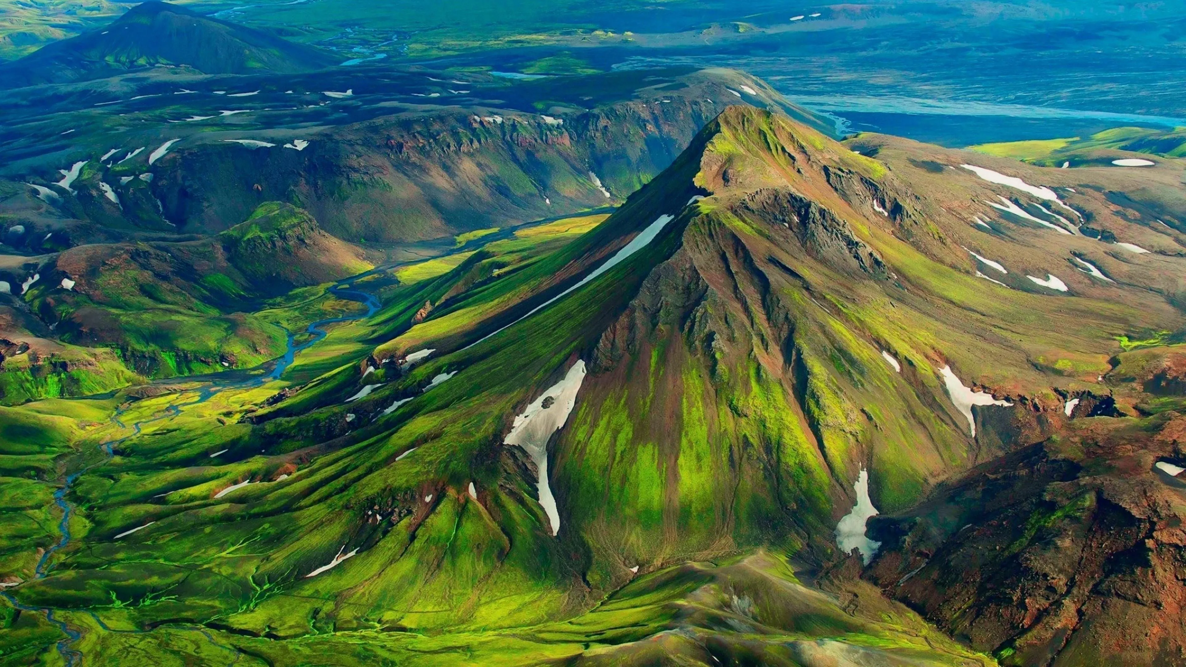 Vibrant Green Mountains and Valley Under a Clear Sky