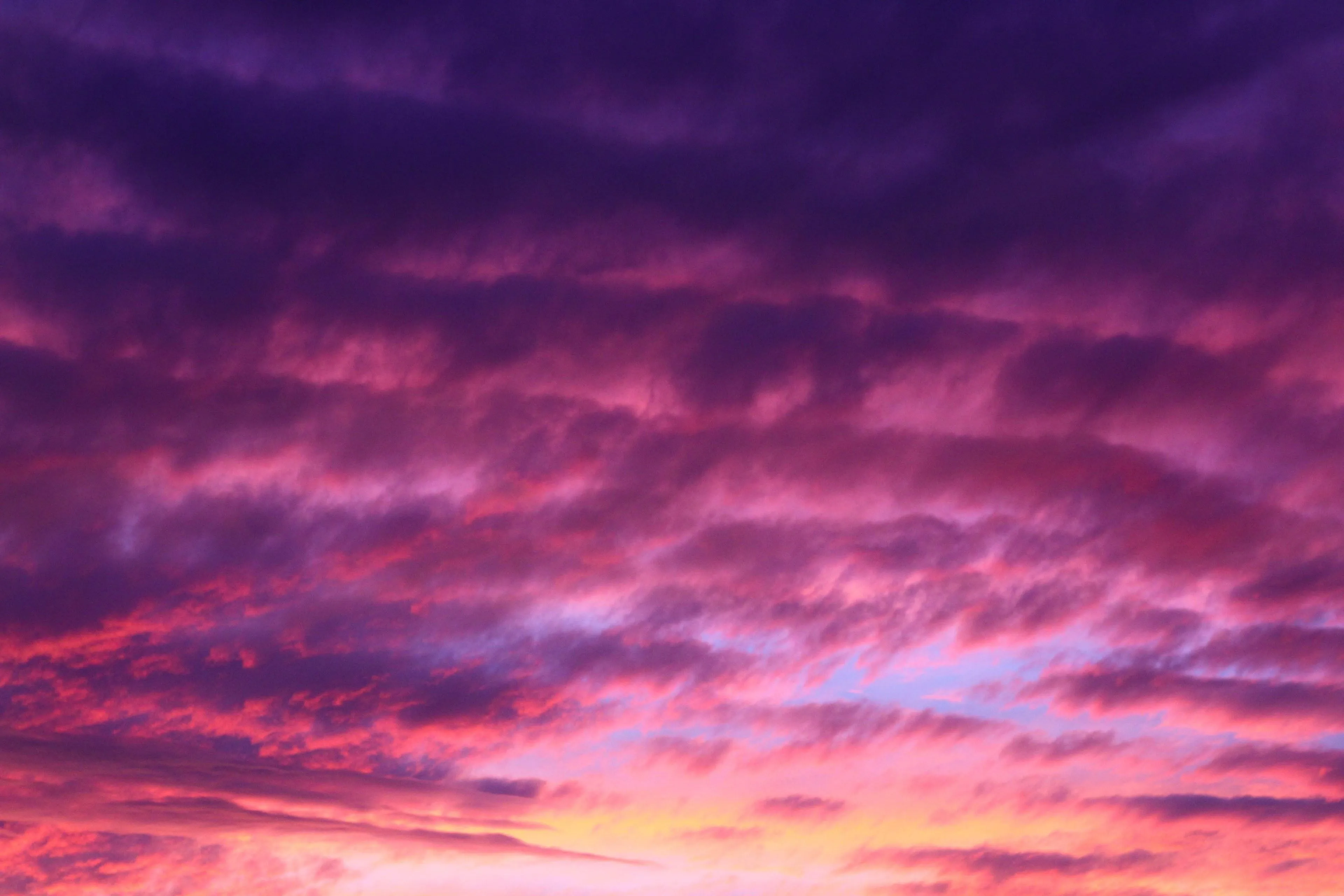 Vibrant Pink and Purple Clouds at Sunset Over Hills