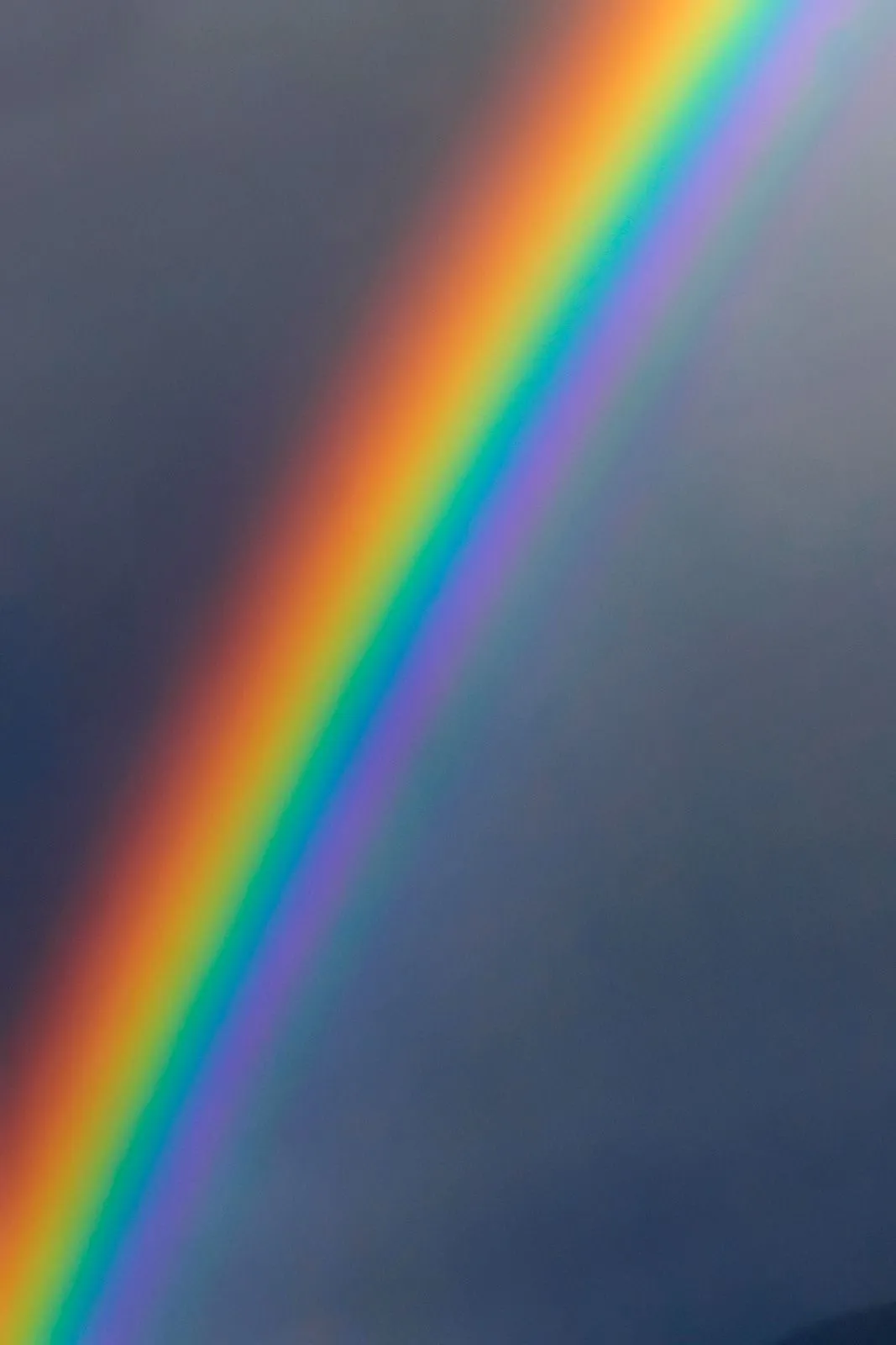 Vibrant Rainbow Appearing in a Cloudy and Moody Sky
