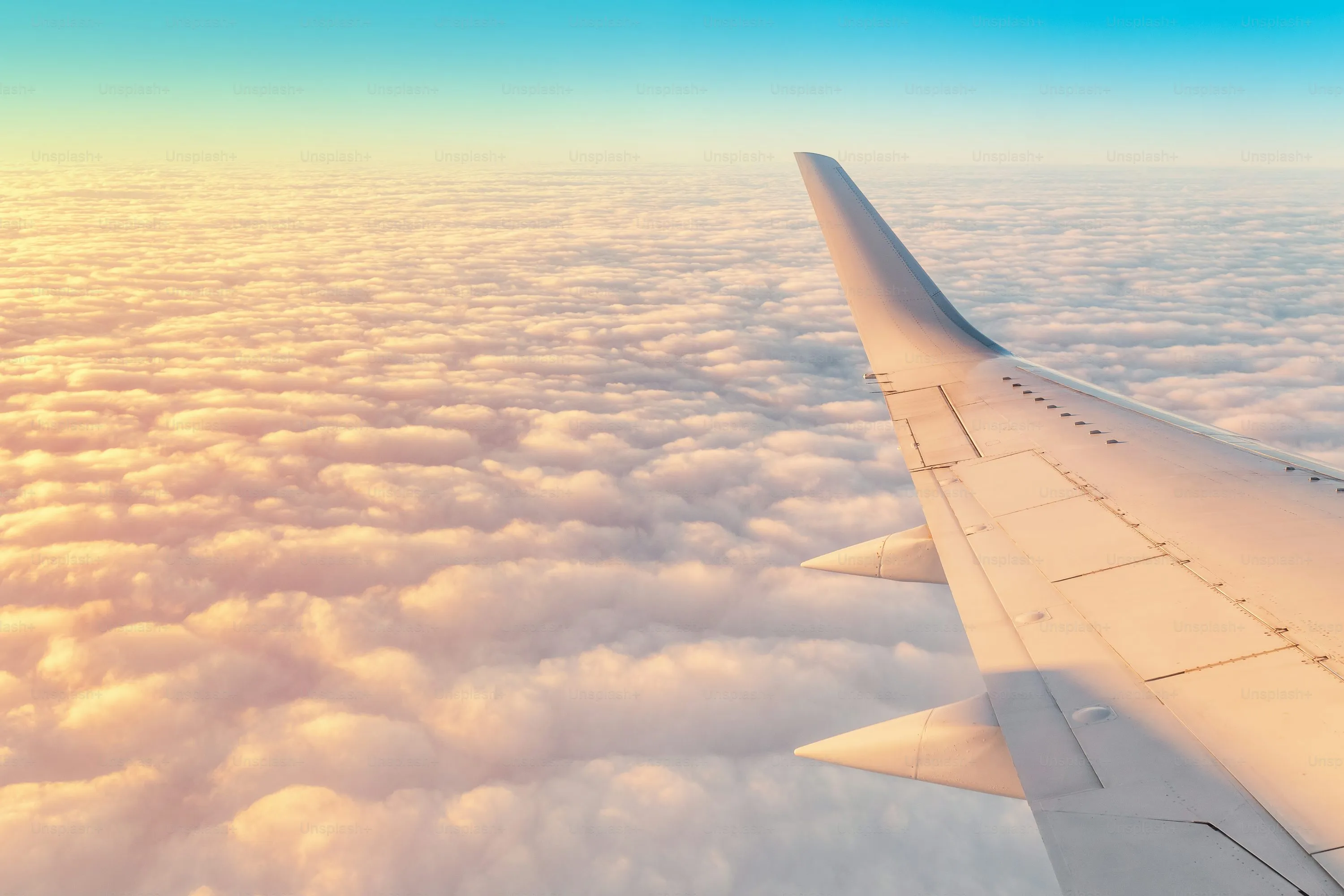 View From Airplane Window Above Thick Clouds at Sunrise
