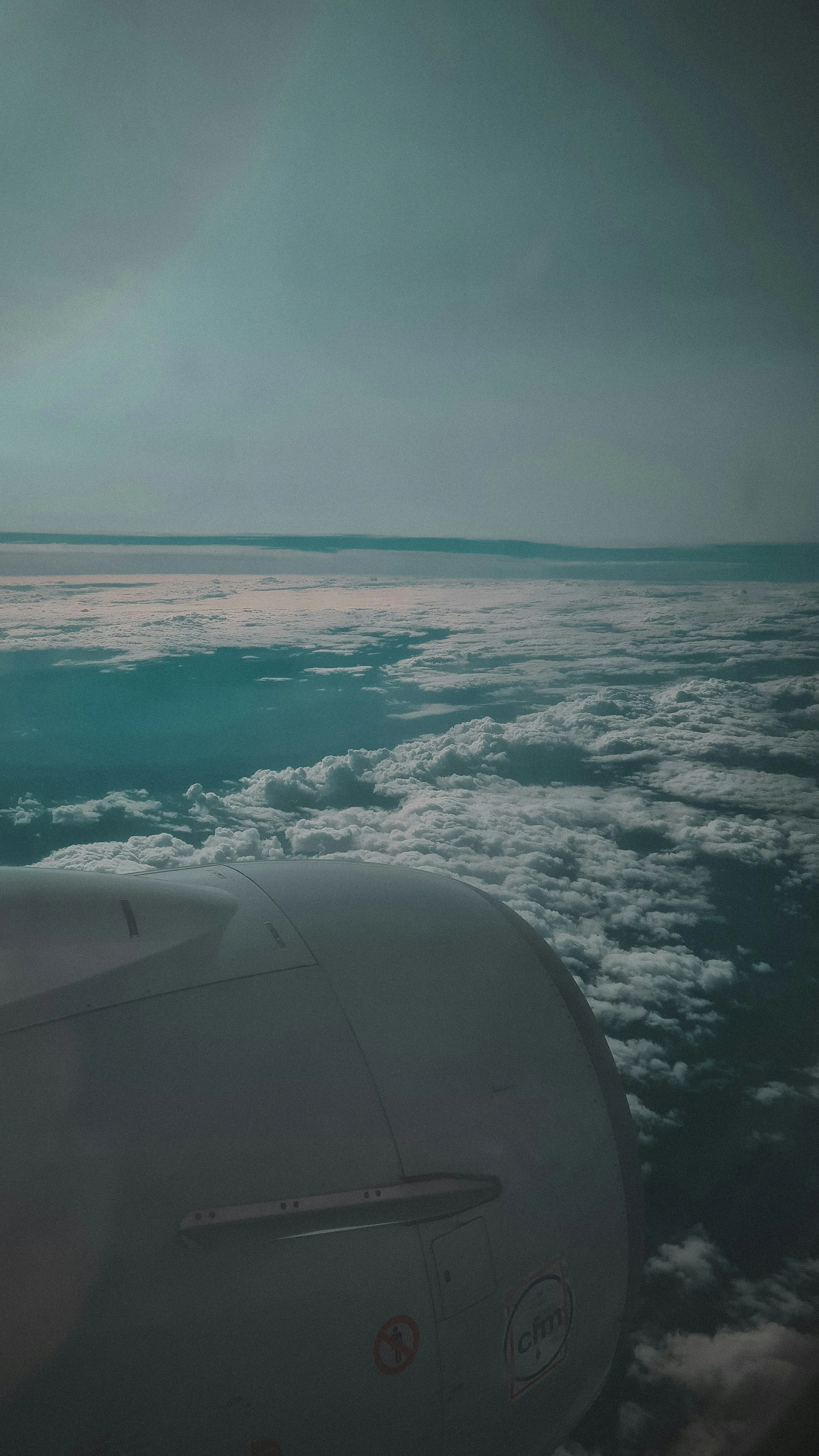 View From Airplane Window Showing Clouds and Blue Horizon
