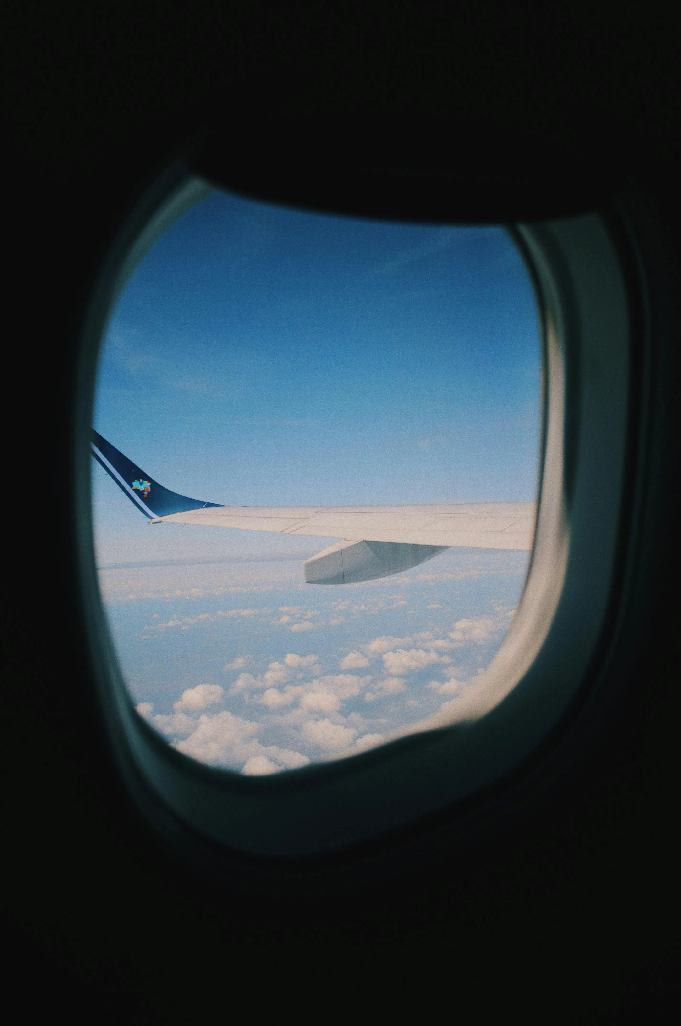 View From Airplane Window Showing Clouds and Blue Sky
