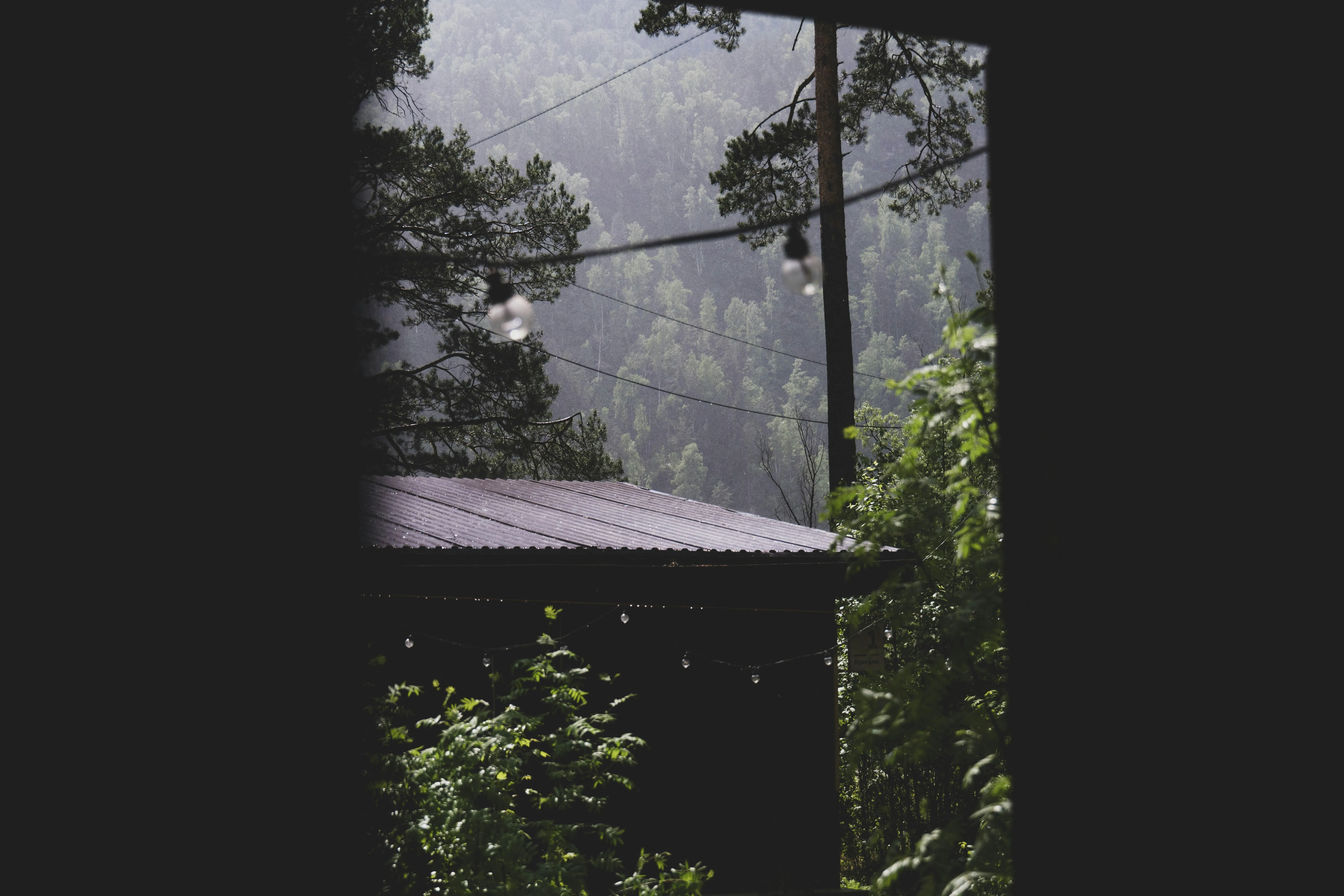 View of Rain Falling Outside a Dark Room Window Image