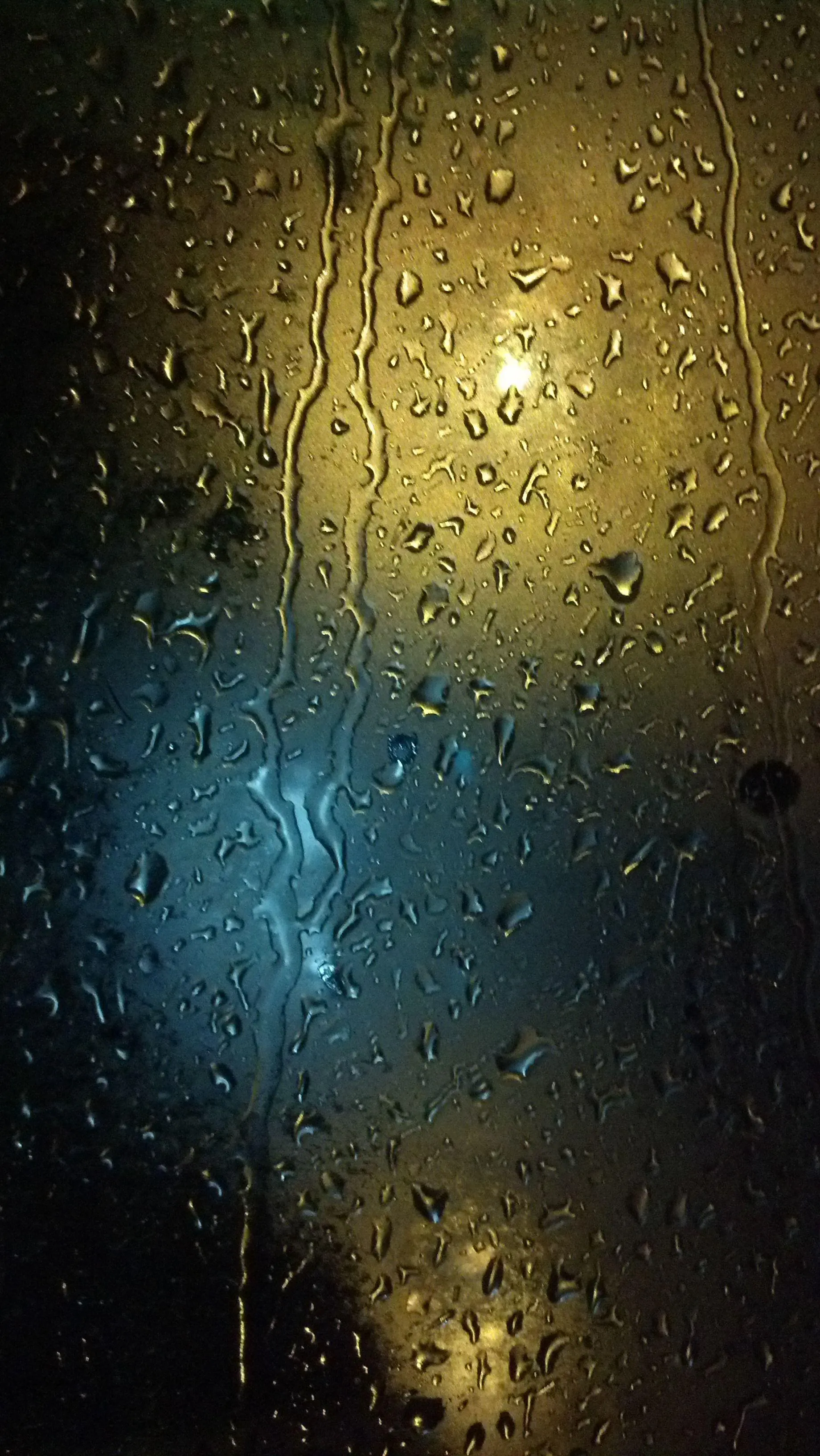 Water Droplets on Glass with Blurred Lights Behind