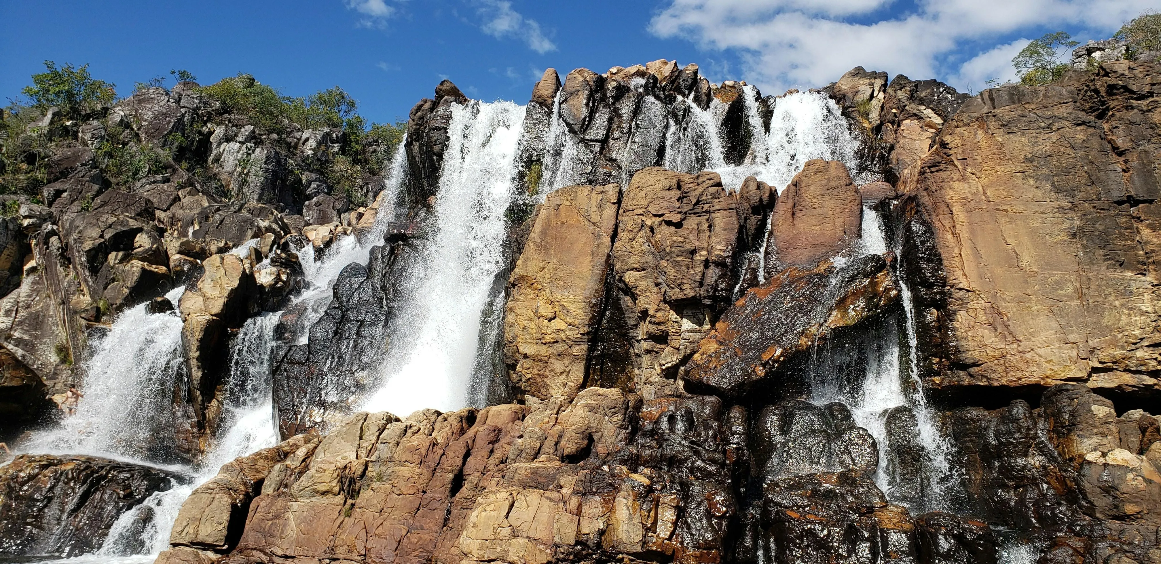 Waterfall flowing over rocks in dense forest environment