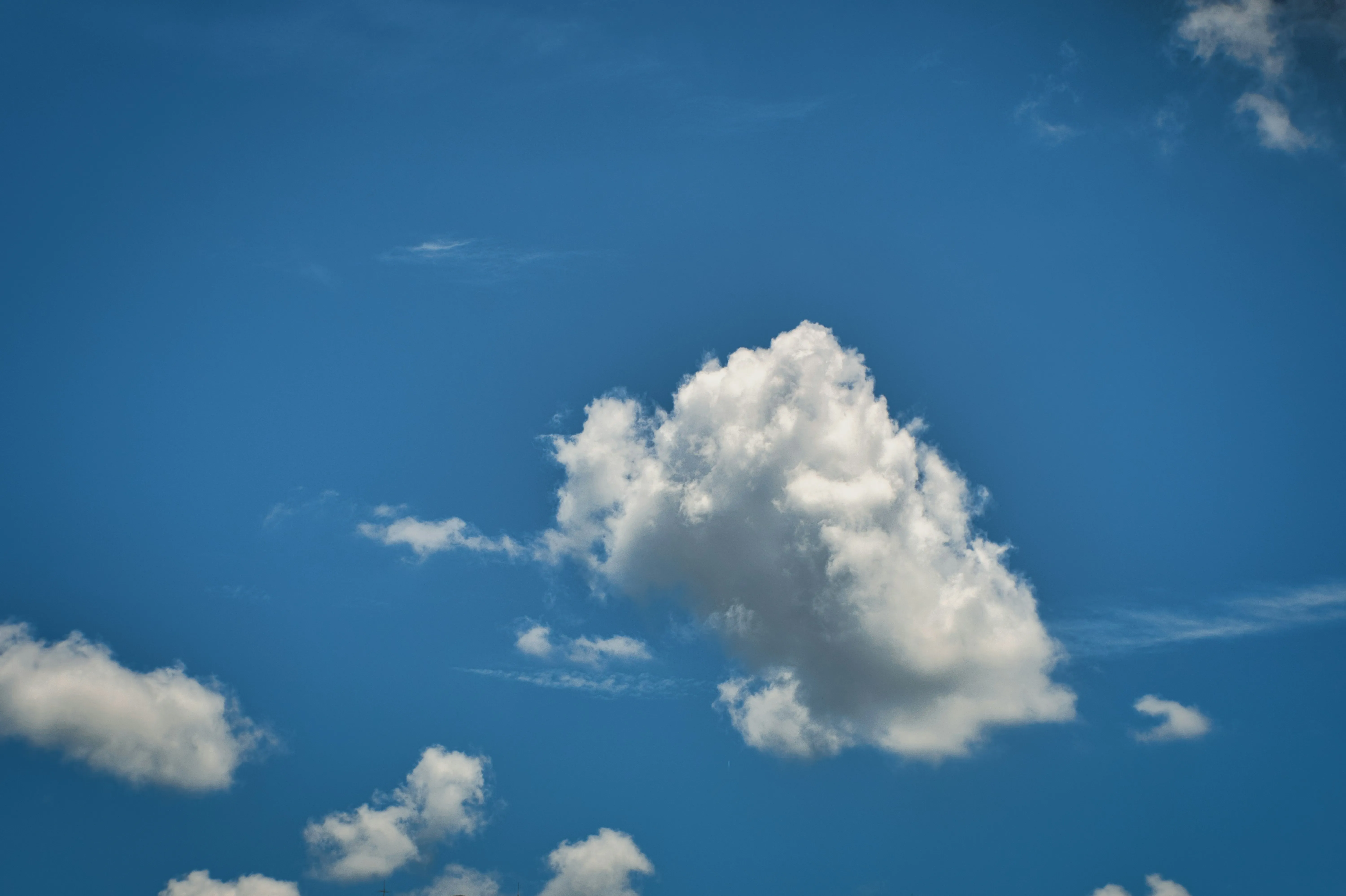 White Cumulus Cloud Drifting in a Clear Blue Sky Wallpaper