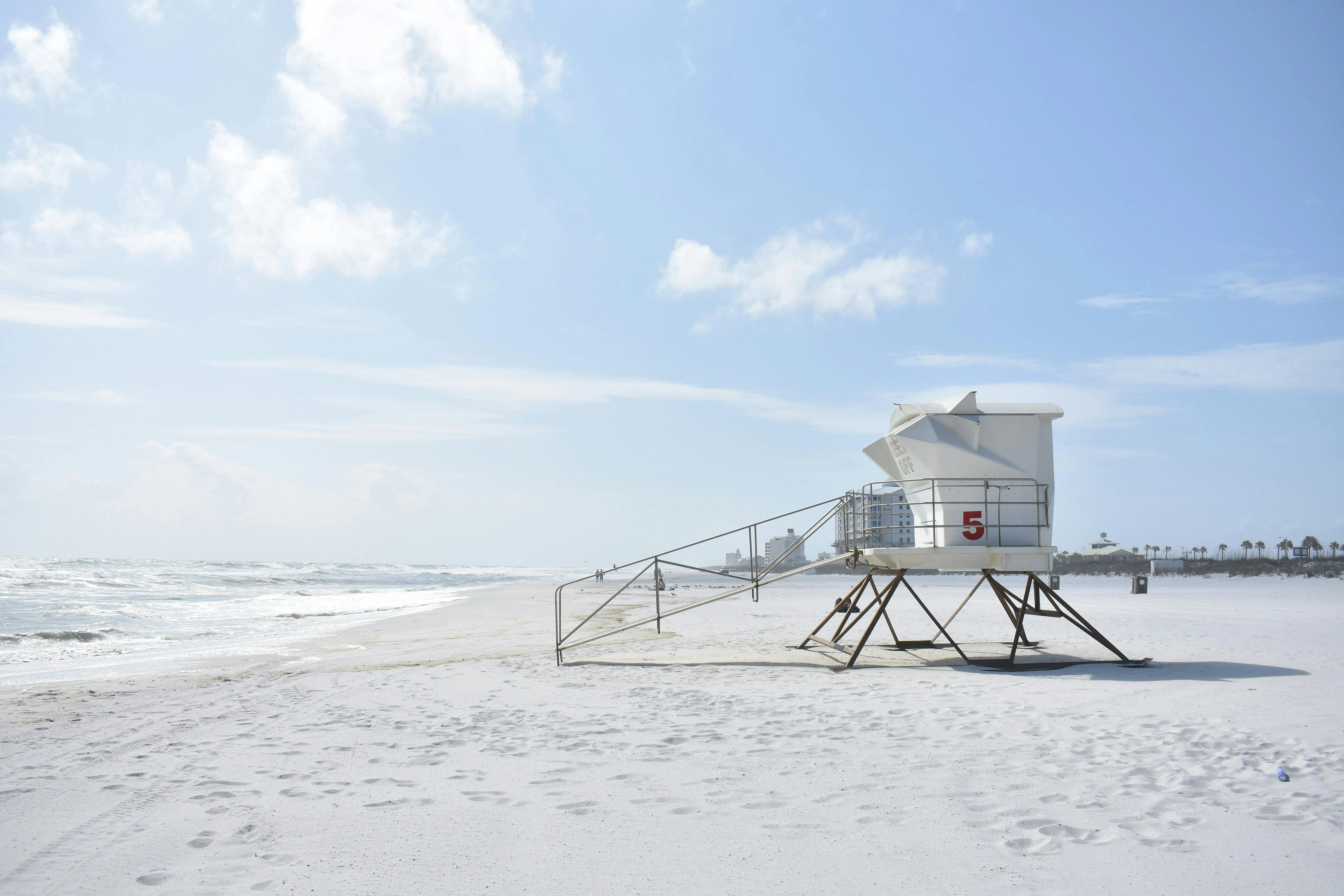White Lifeguard Tower on Sandy Beach Under Blue Sky
