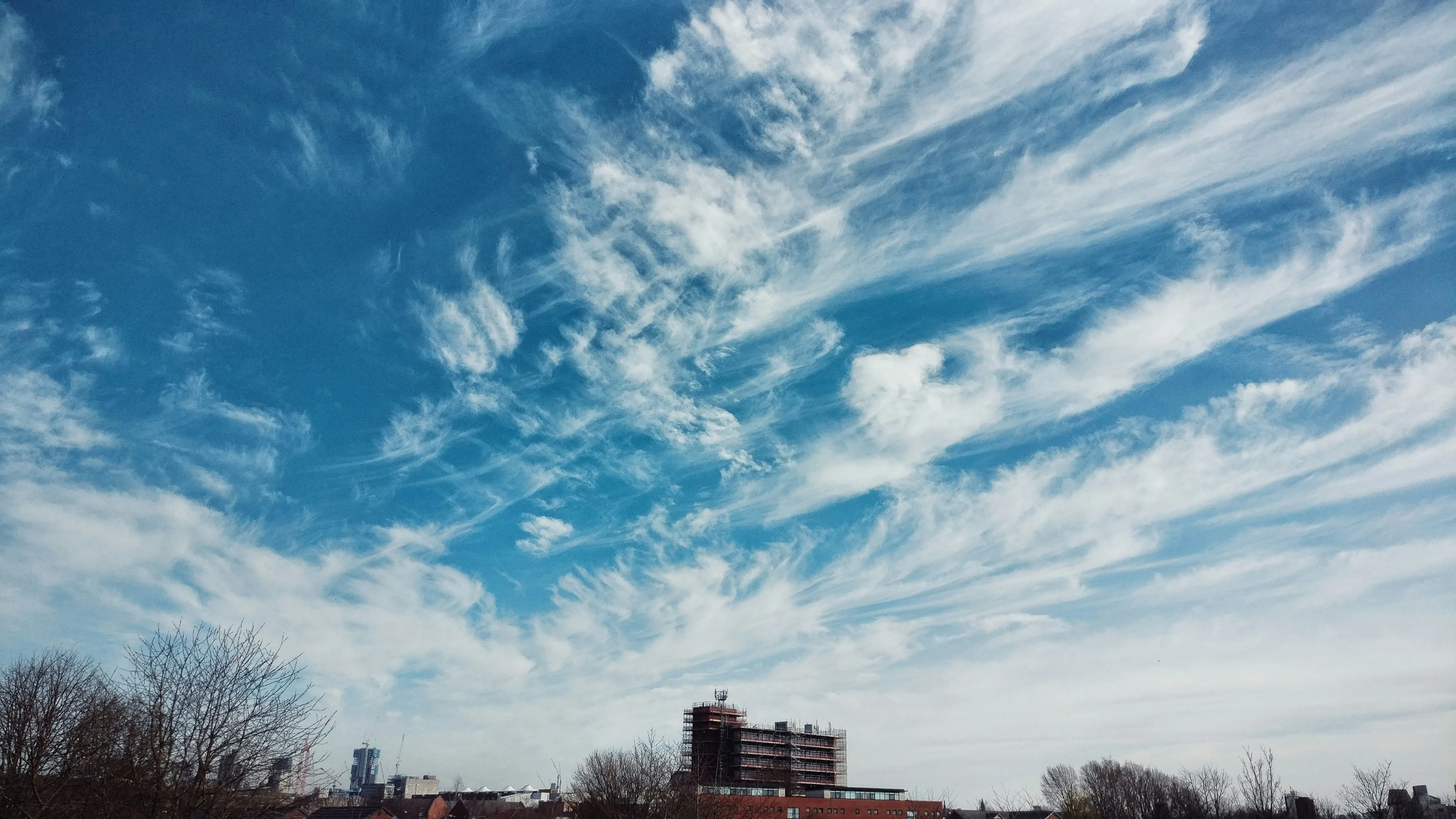 Wide Blue Sky with Fast Moving Clouds Over Open Land