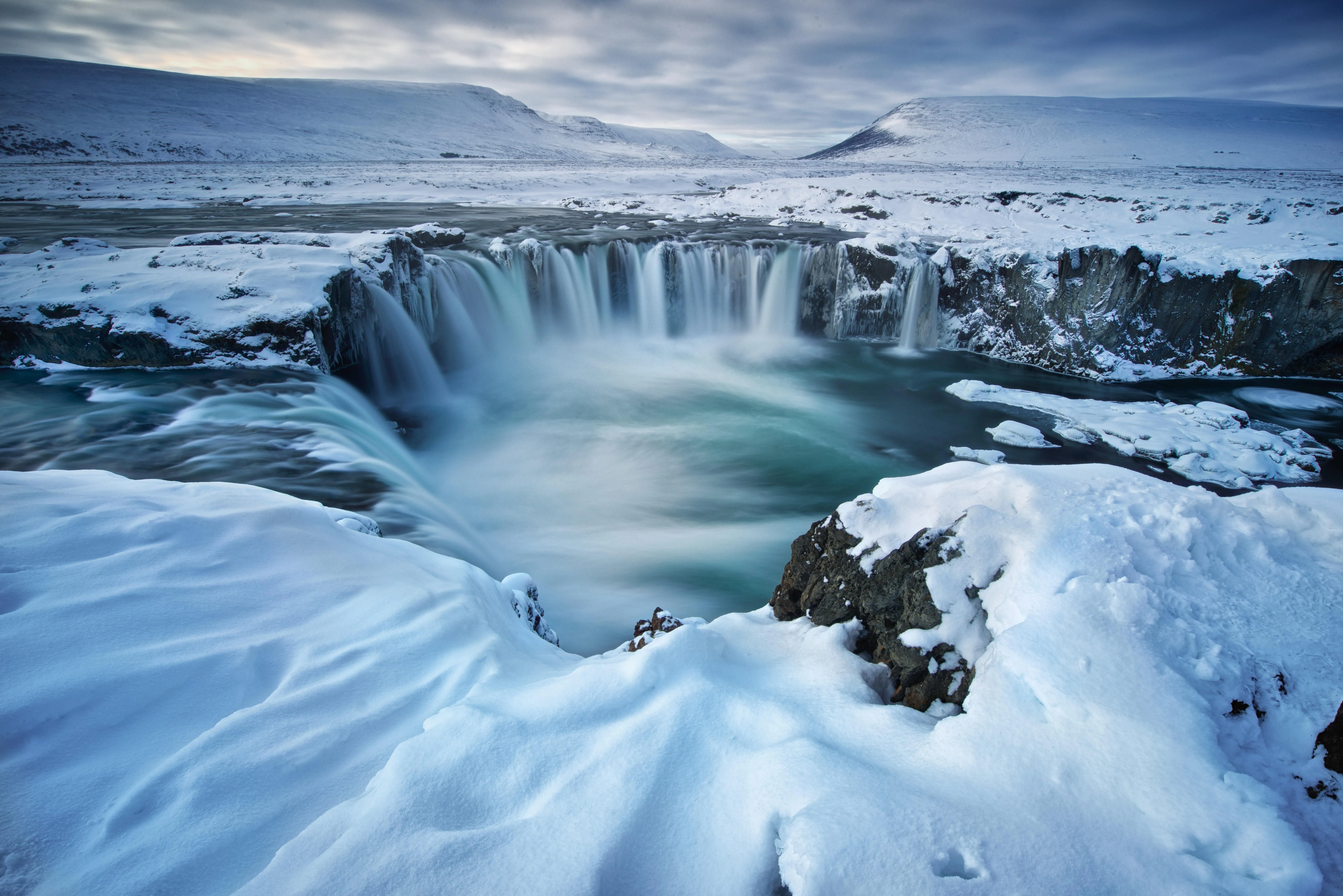 Wide River Falls Surrounded by Rocks and Trees Wallpaper
