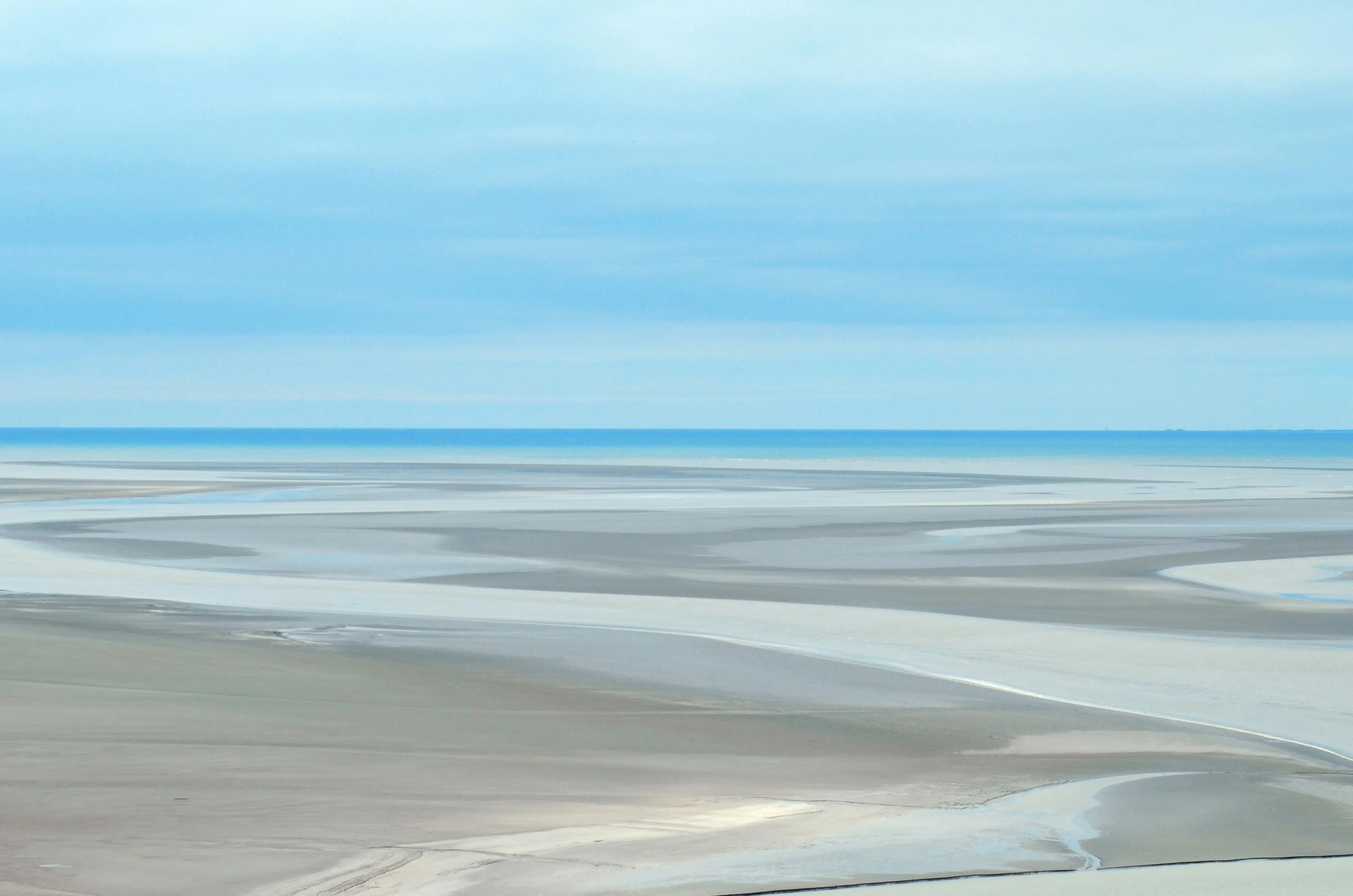 Wide Sandy Beach with Calm Water and Blue Sky Wallpaper