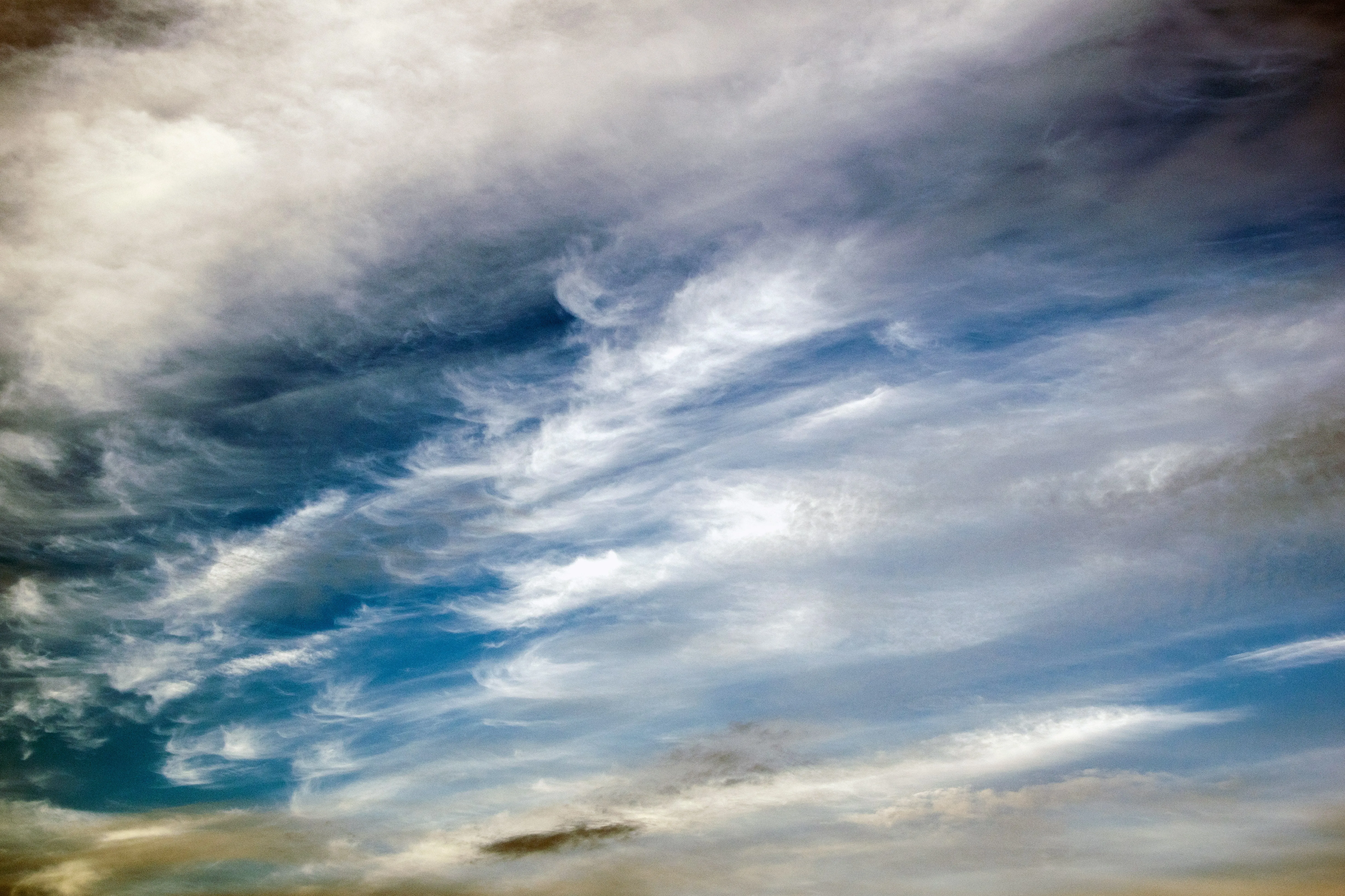Wind Swept Clouds Moving Across a Clear Sky Over Land