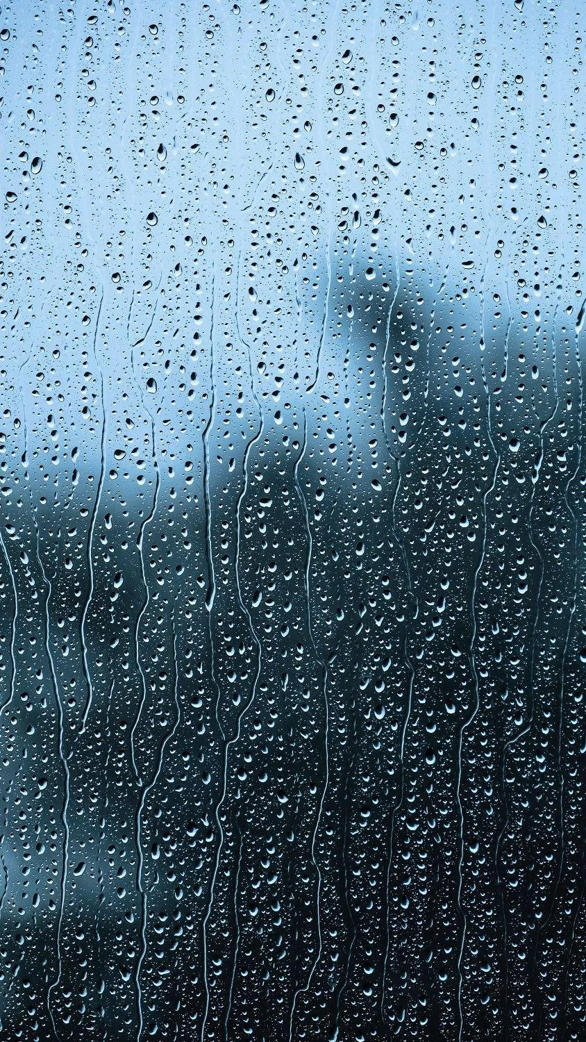 Window Covered in Water Droplets with Blurred Background