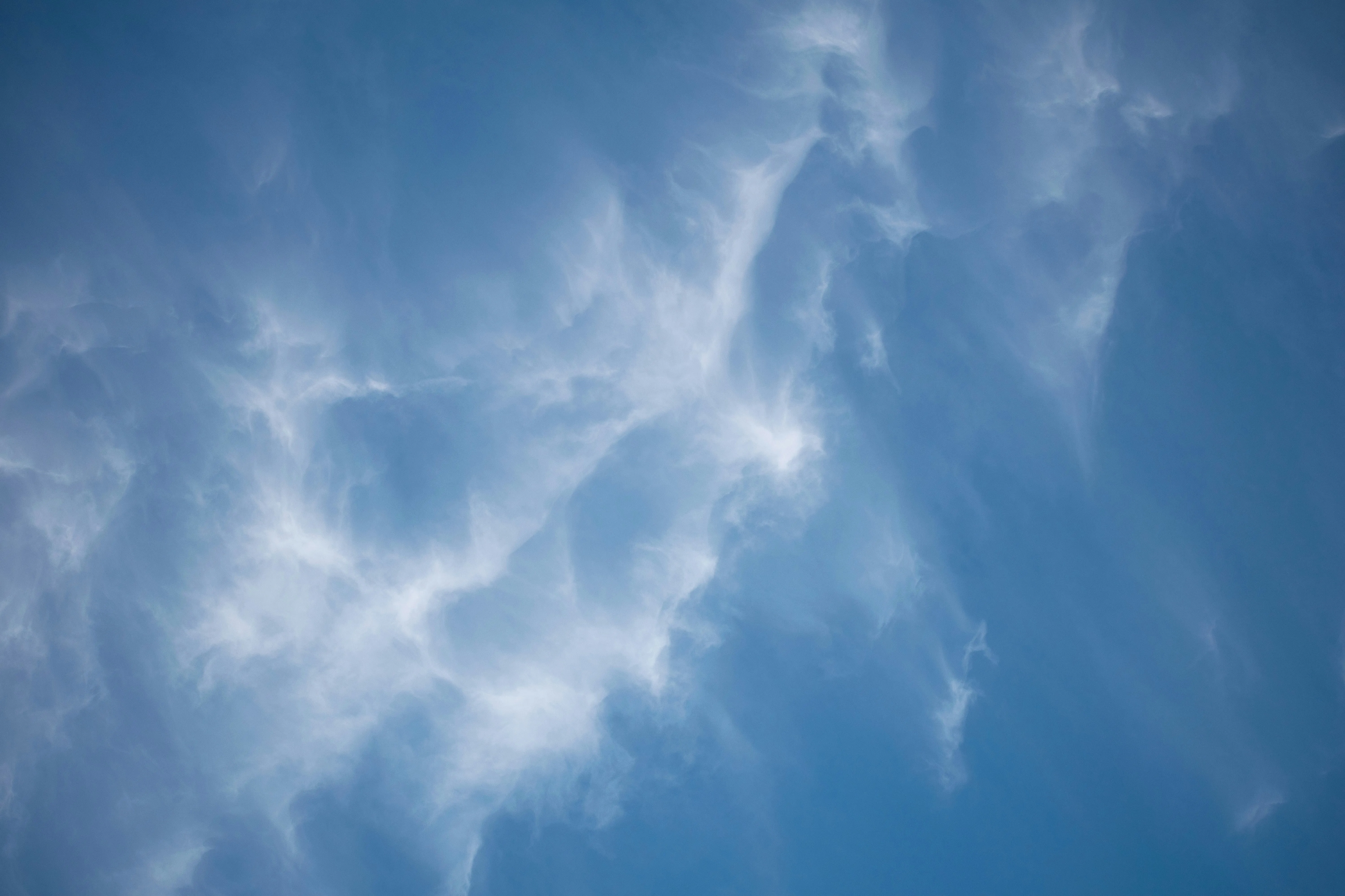 Wispy Cirrus Clouds Swirling Across the Blue Sky Wallpaper