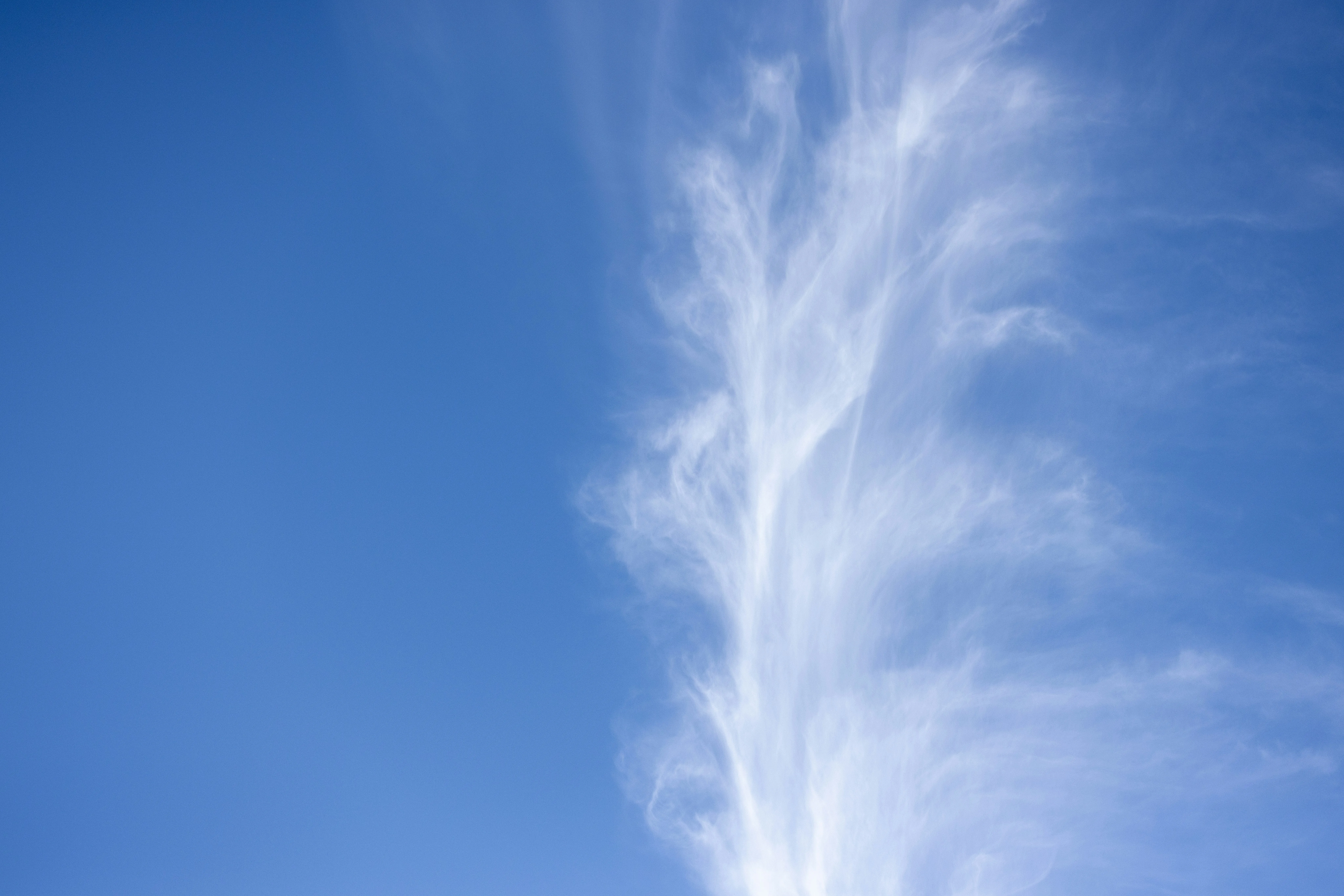 Wispy White Cirrus Cloud Stretching in Blue Sky Wallpaper