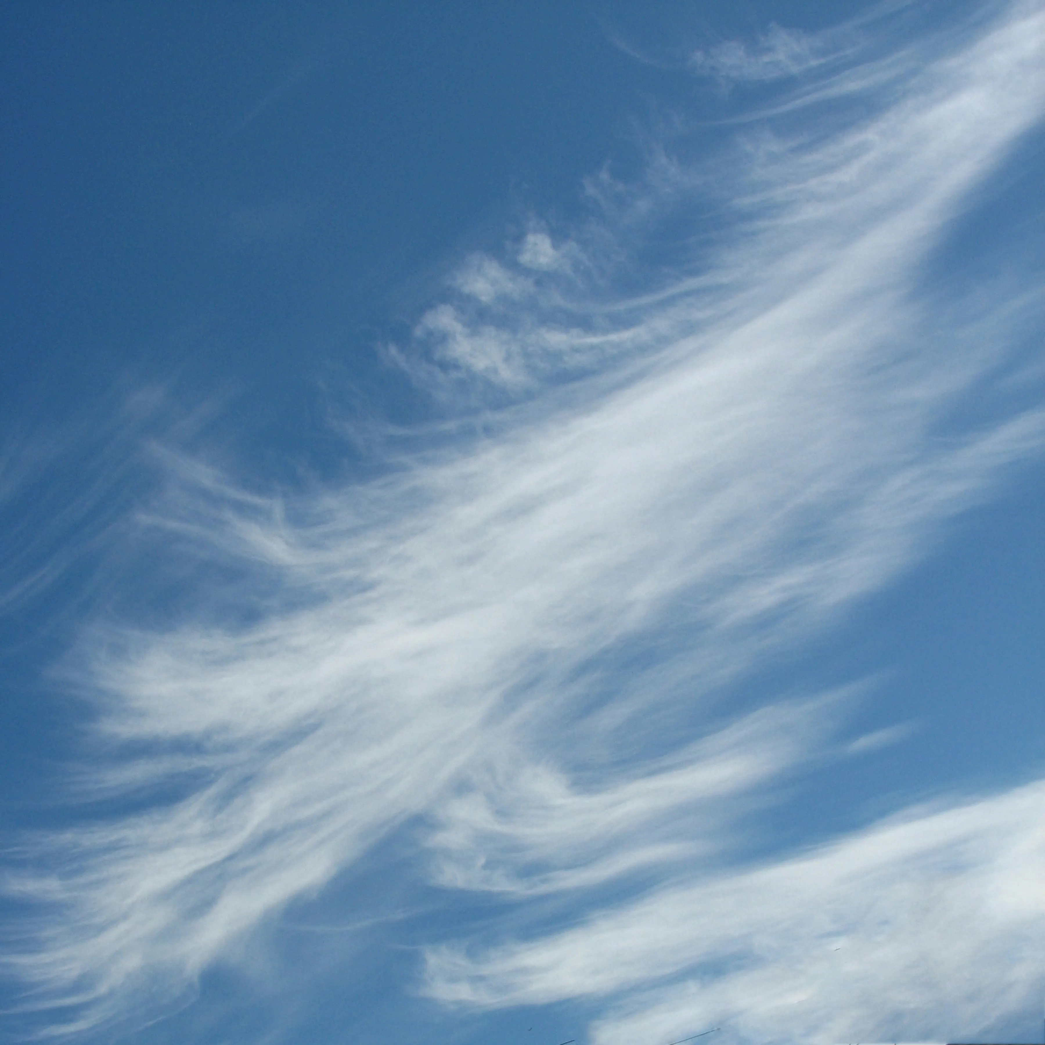 Wispy White Clouds Stretching Across Blue Sky Wallpaper