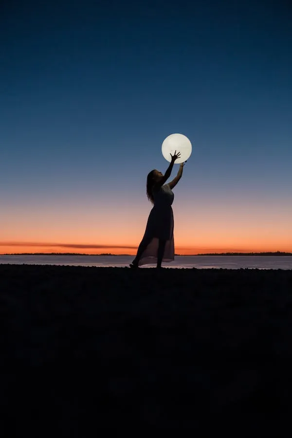 Woman Holding Moon Silhouette Under Orange Twilight