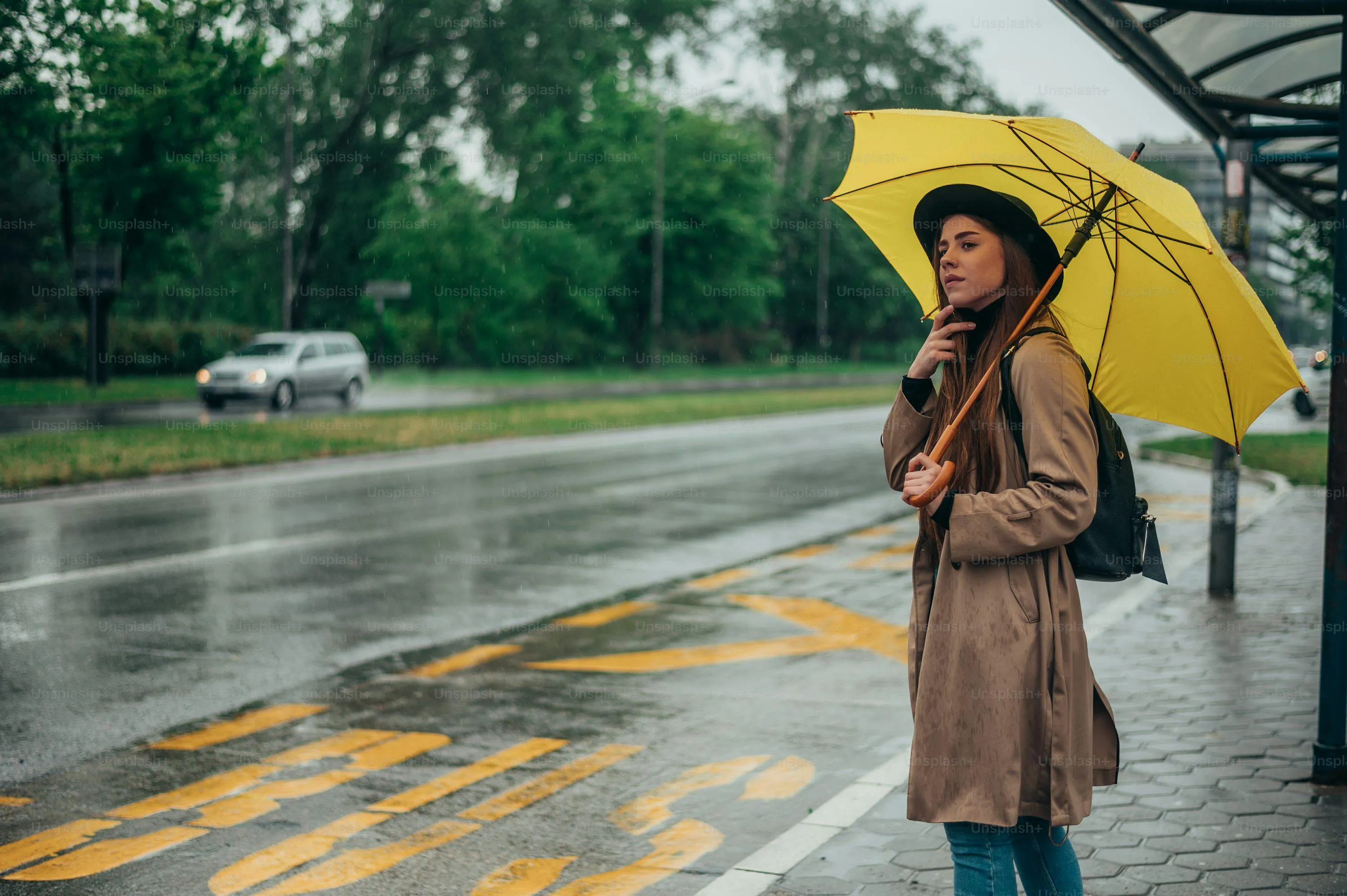 Woman in Yellow Raincoat Walking on Wet Road with Umbrella