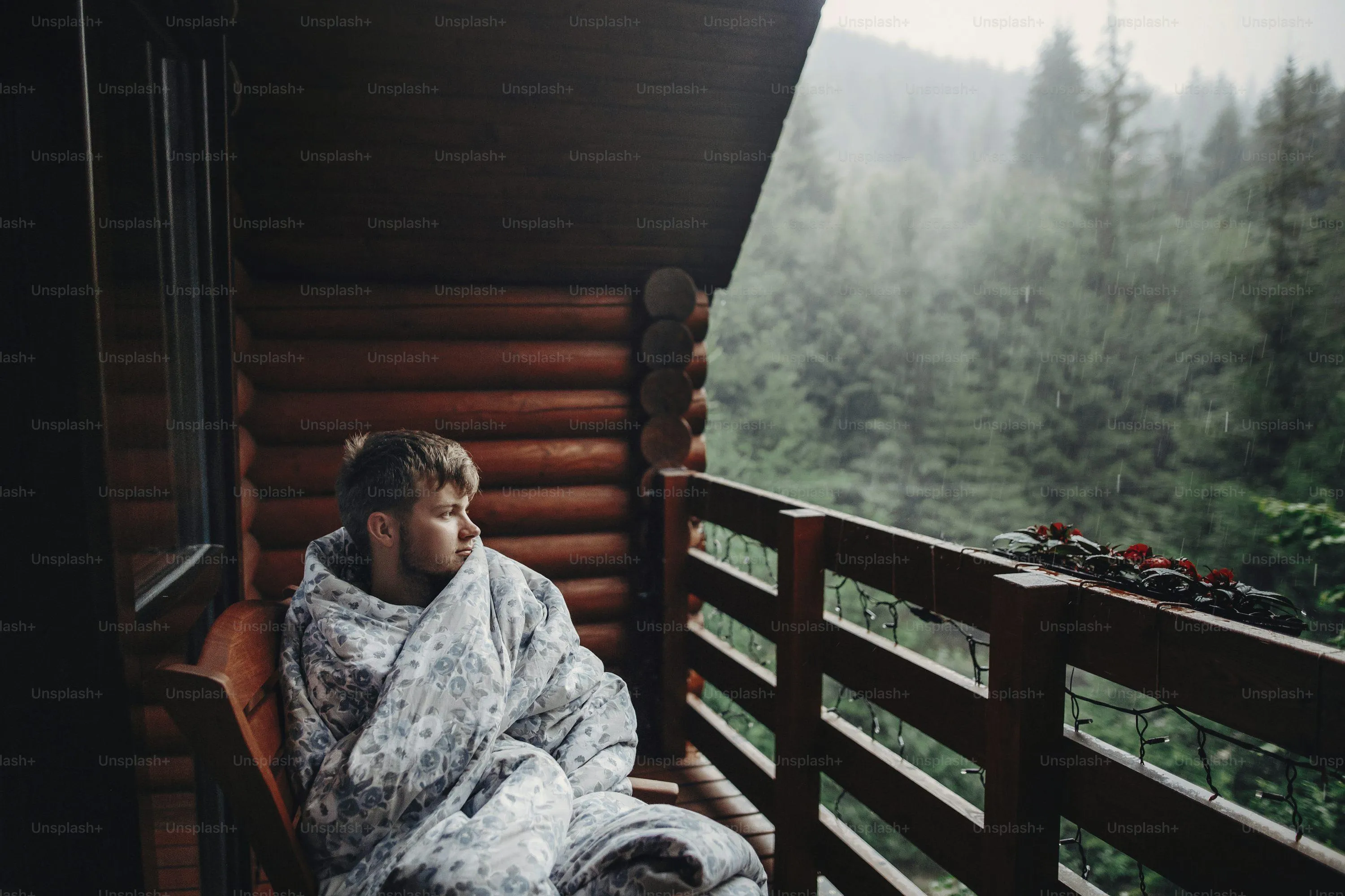 Woman Sitting on Wooden Deck Surrounded By Rain and Fog