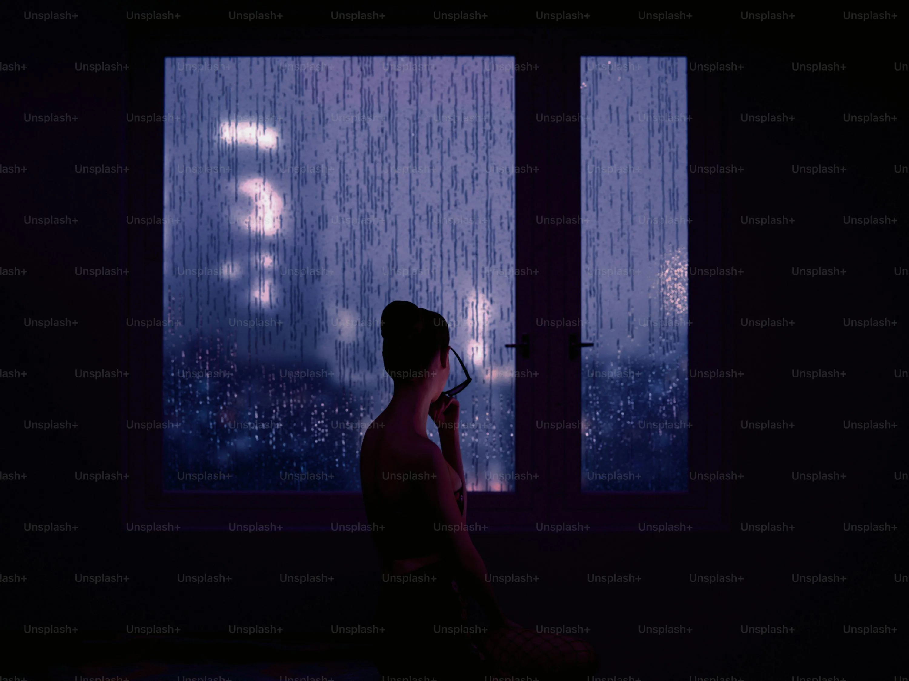 Woman Standing in Doorway Watching Rain Through Window