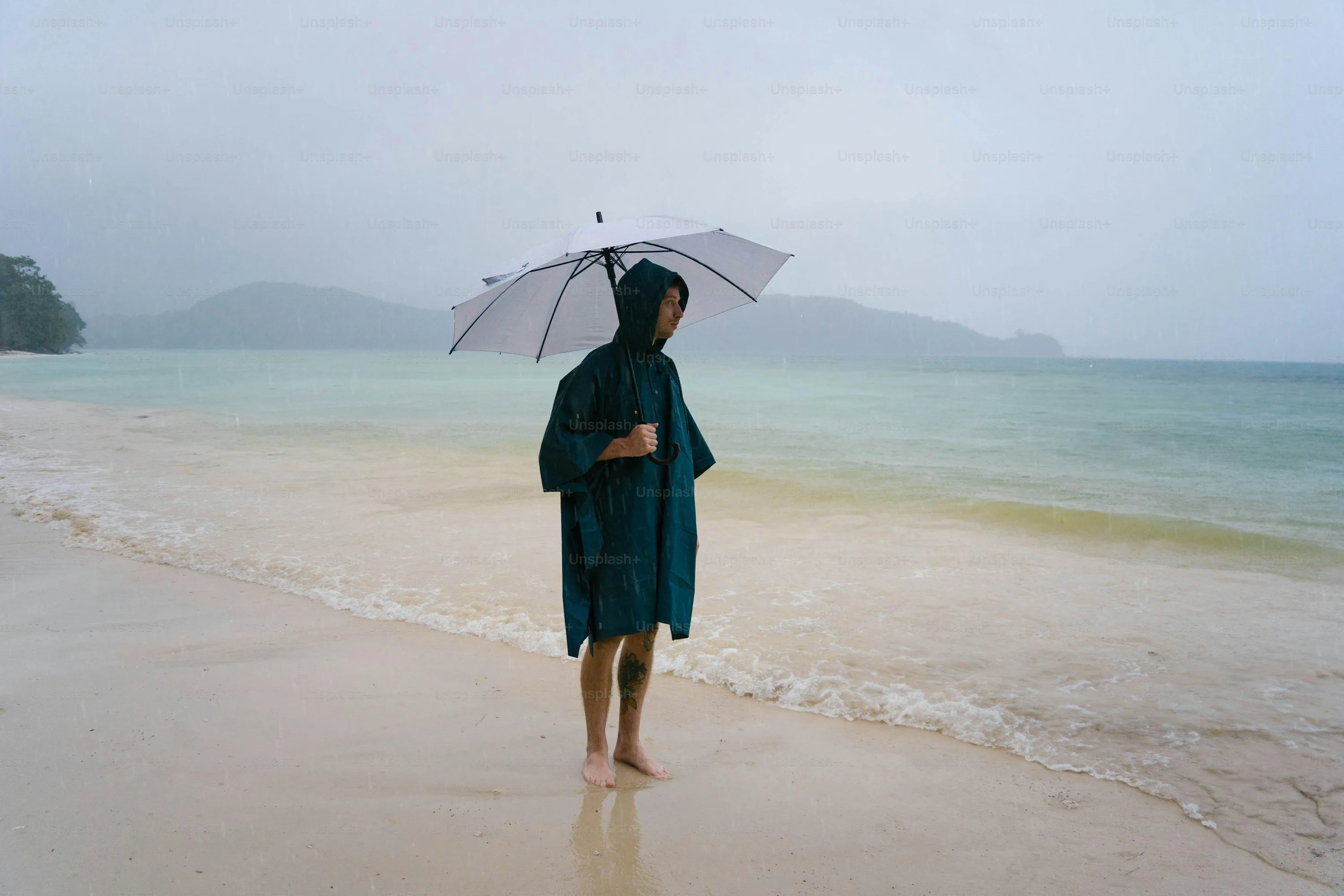 Woman Walking on Beach Holding Umbrella in Rain