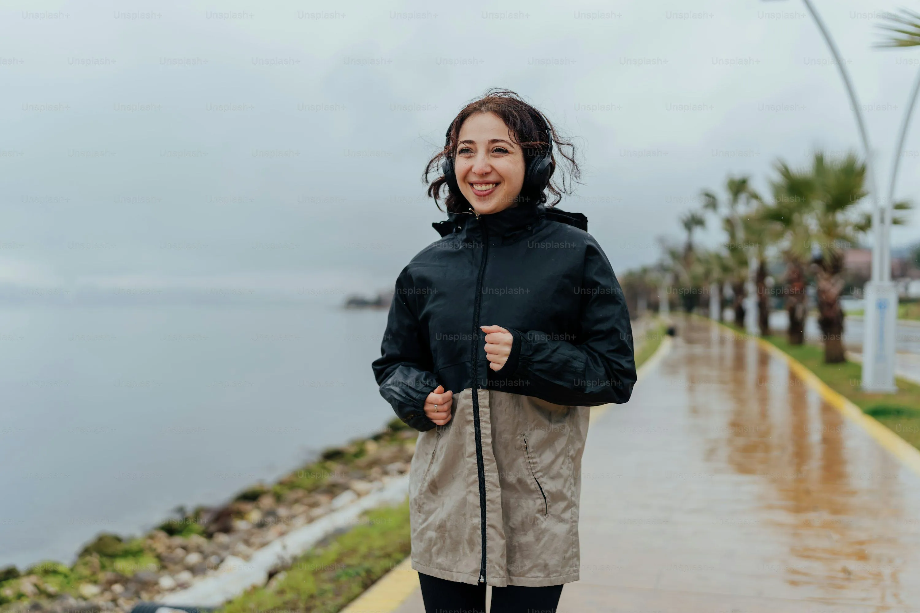 Woman Walking Outside Wearing Raincoat and Boots Walllpaper