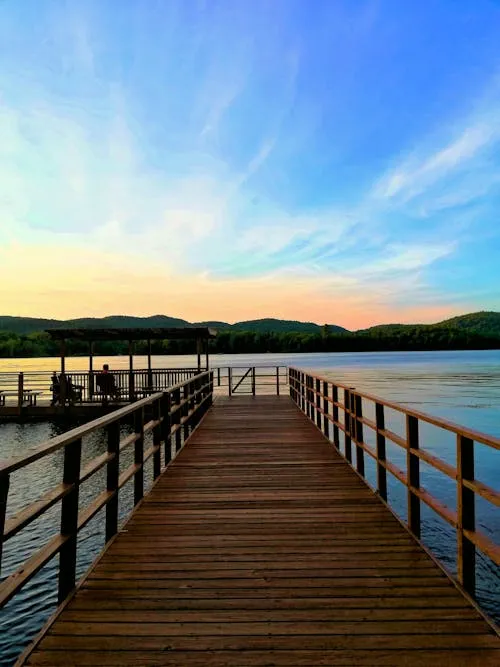 Wooden Pier Leading Out Into a Calm Lake at Sunrise
