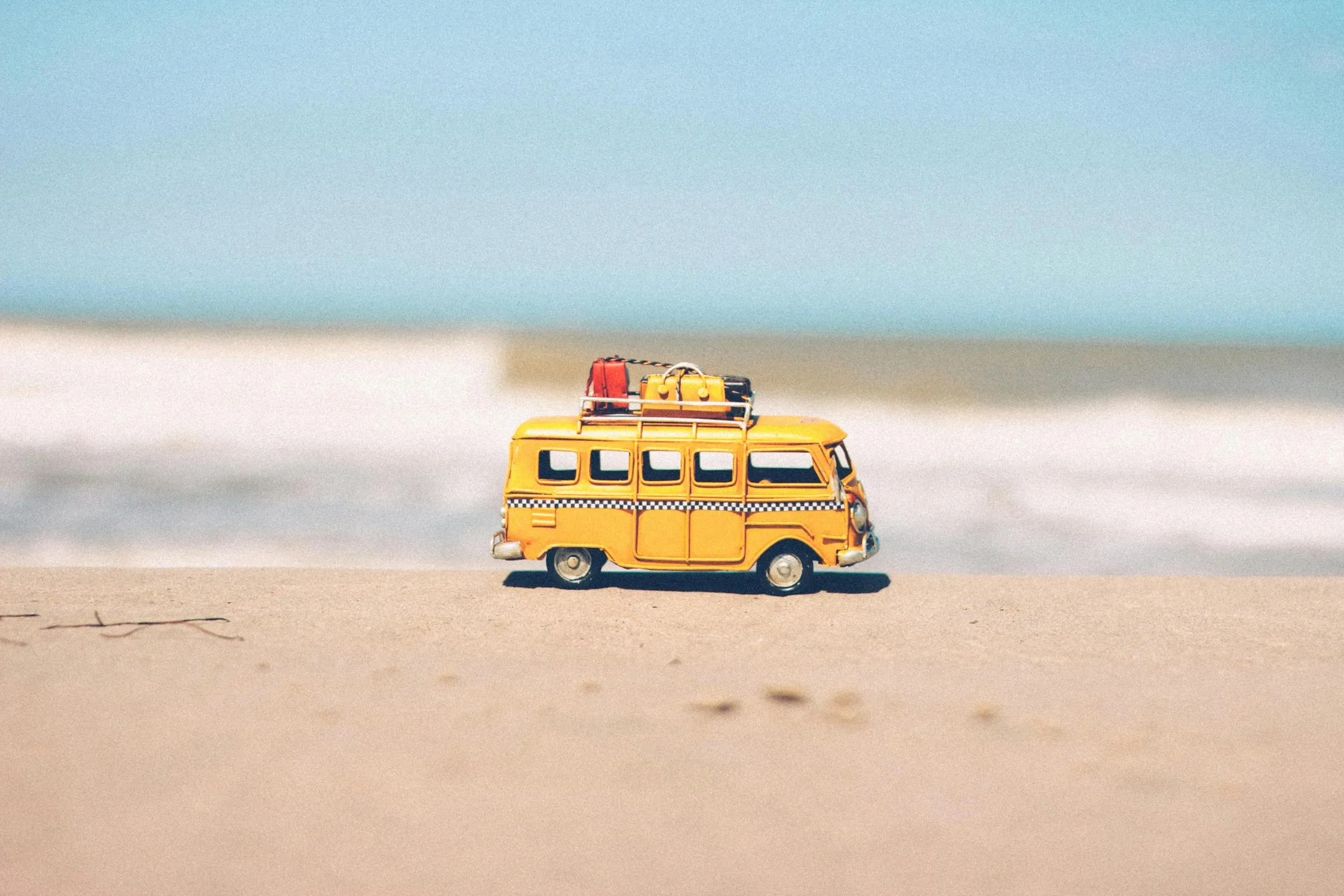 Yellow Toy School Bus Parked Under Bright Cloudy Sky