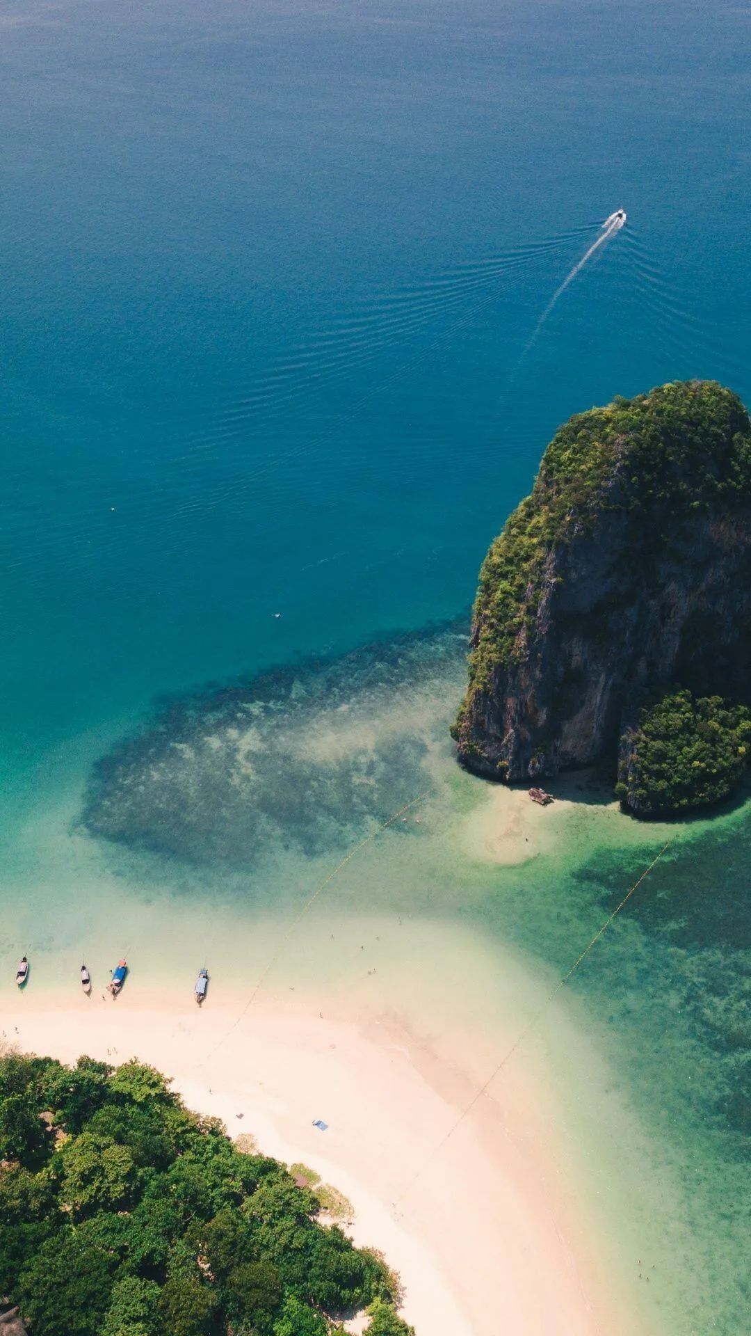 Aerial View of a Beach with Rocky Cliffs and Clear Water