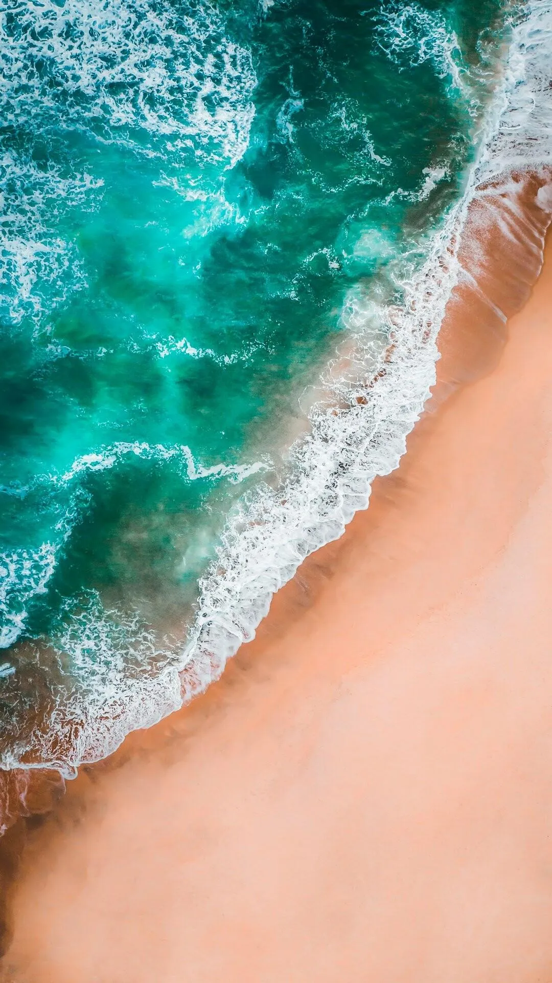 Aerial View of Beach with Teal Waves and Orange Sand
