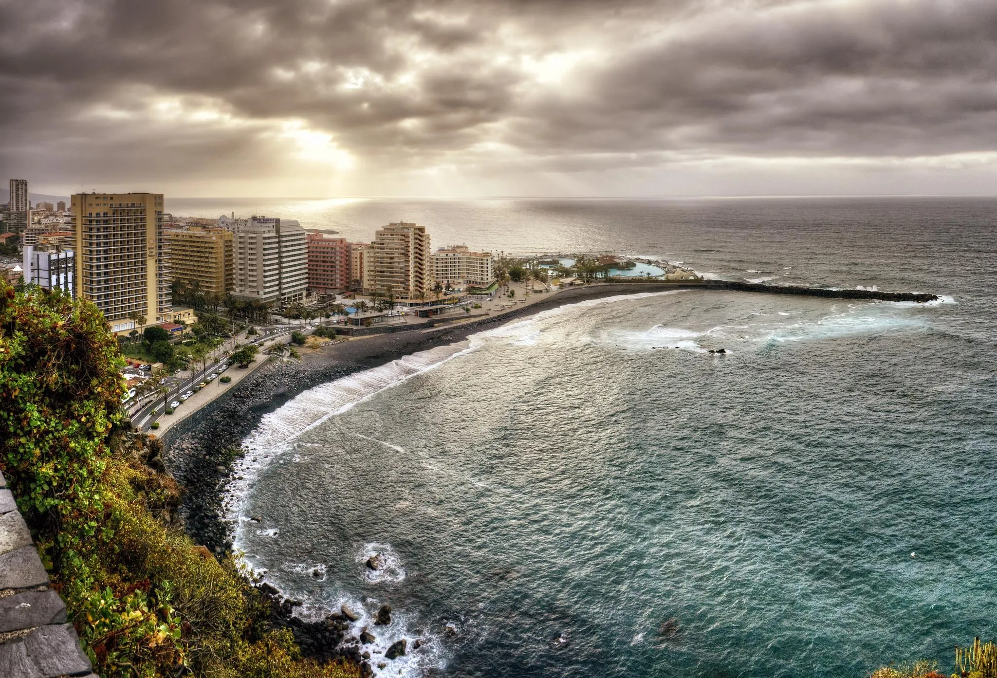 Aerial View of a Coastal City with an Ocean Curve and Towers