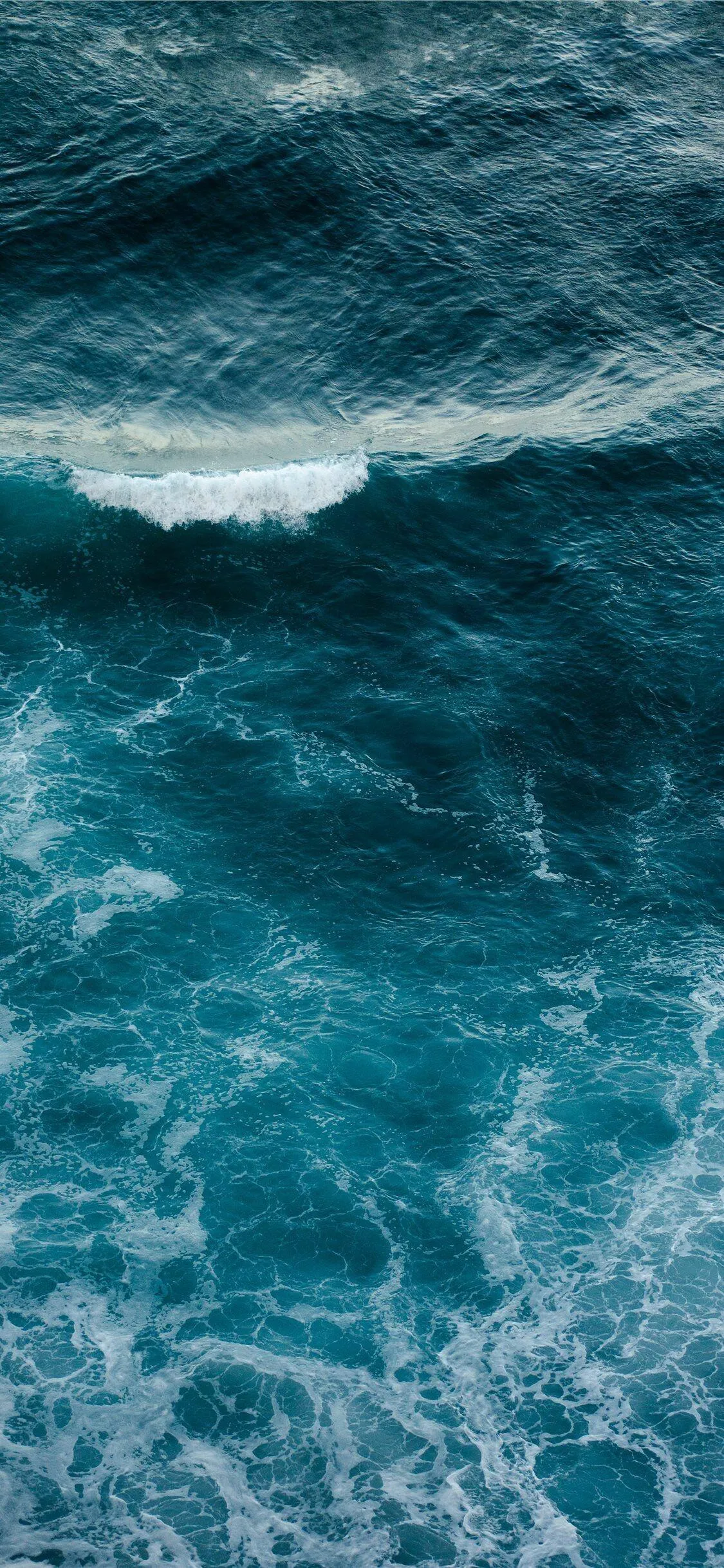 Aerial View of Deep Blue Ocean Waves Crashing Free Wallpaper