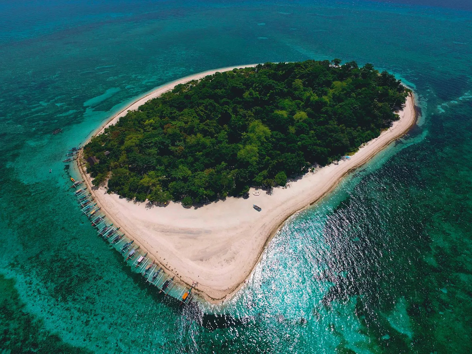 Aerial View of a Green Island Surrounded by Clear Water