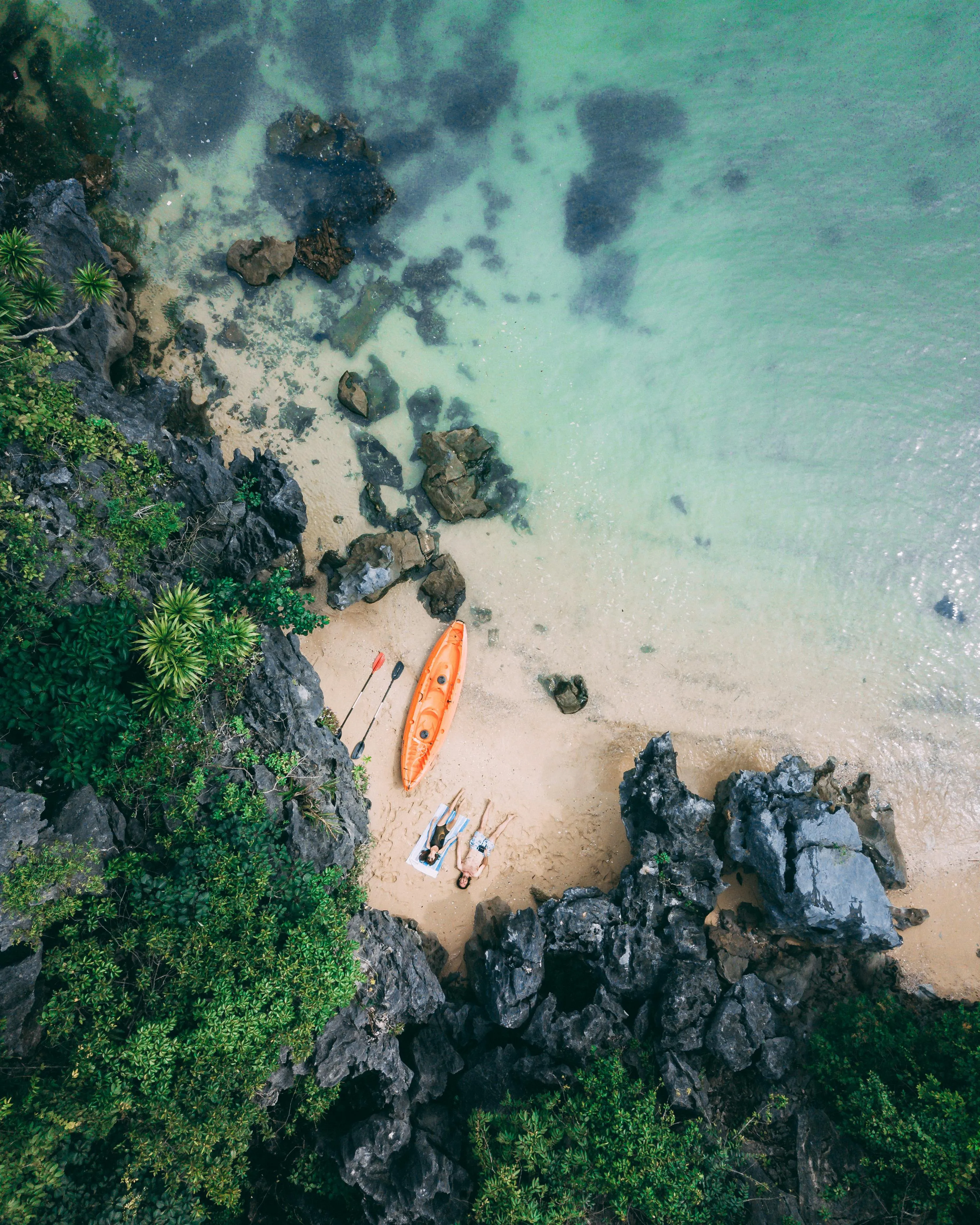 Aerial View of a Small Beach with a Boat and Rocky Forest