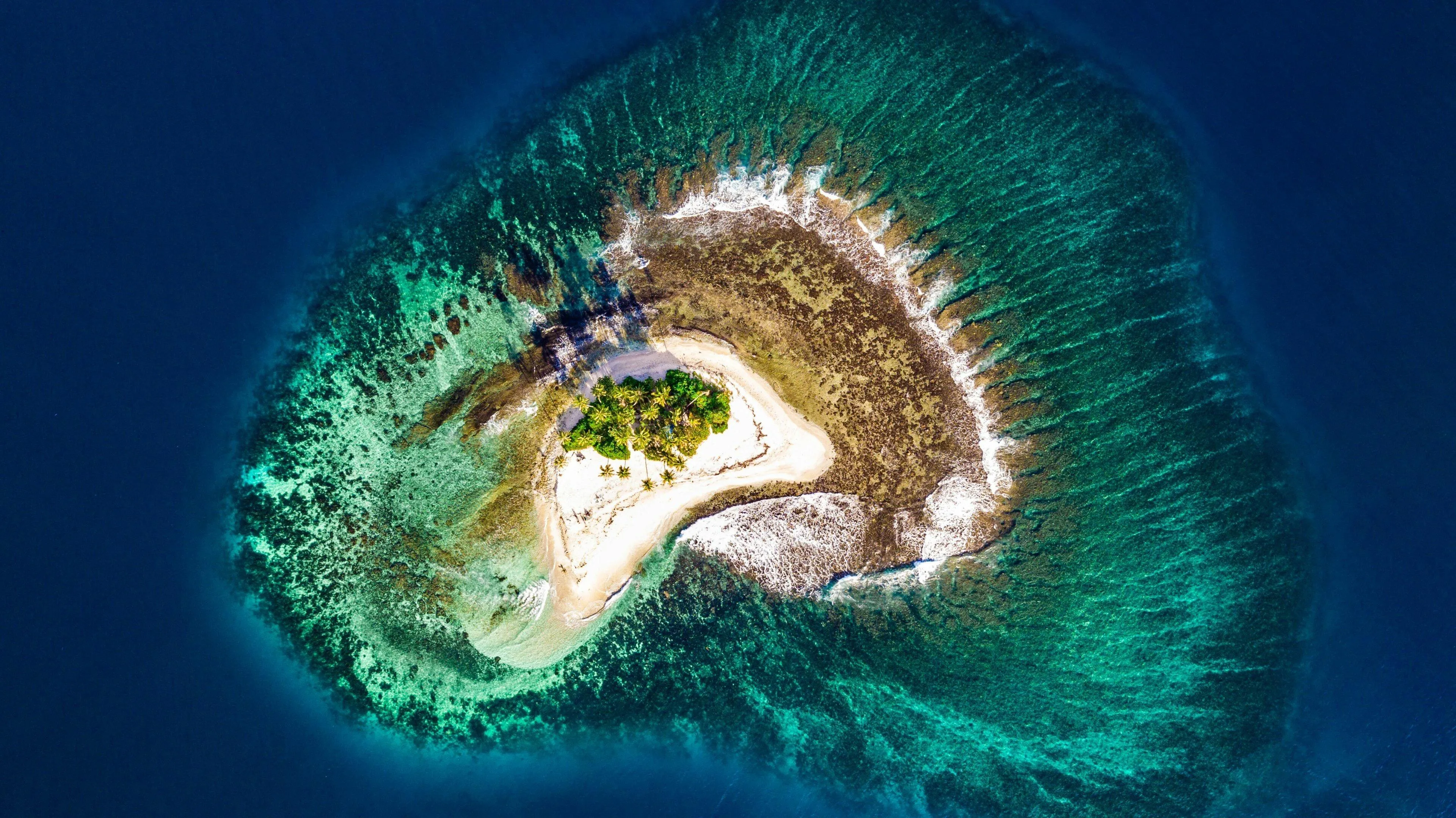 Aerial View of a Tiny Island Surrounded by Deep Blue Water