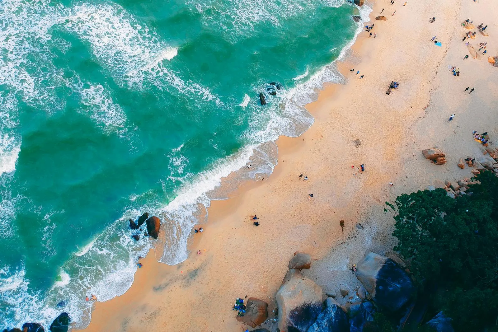 Aerial View of Waves Crashing on a Busy Golden Beach