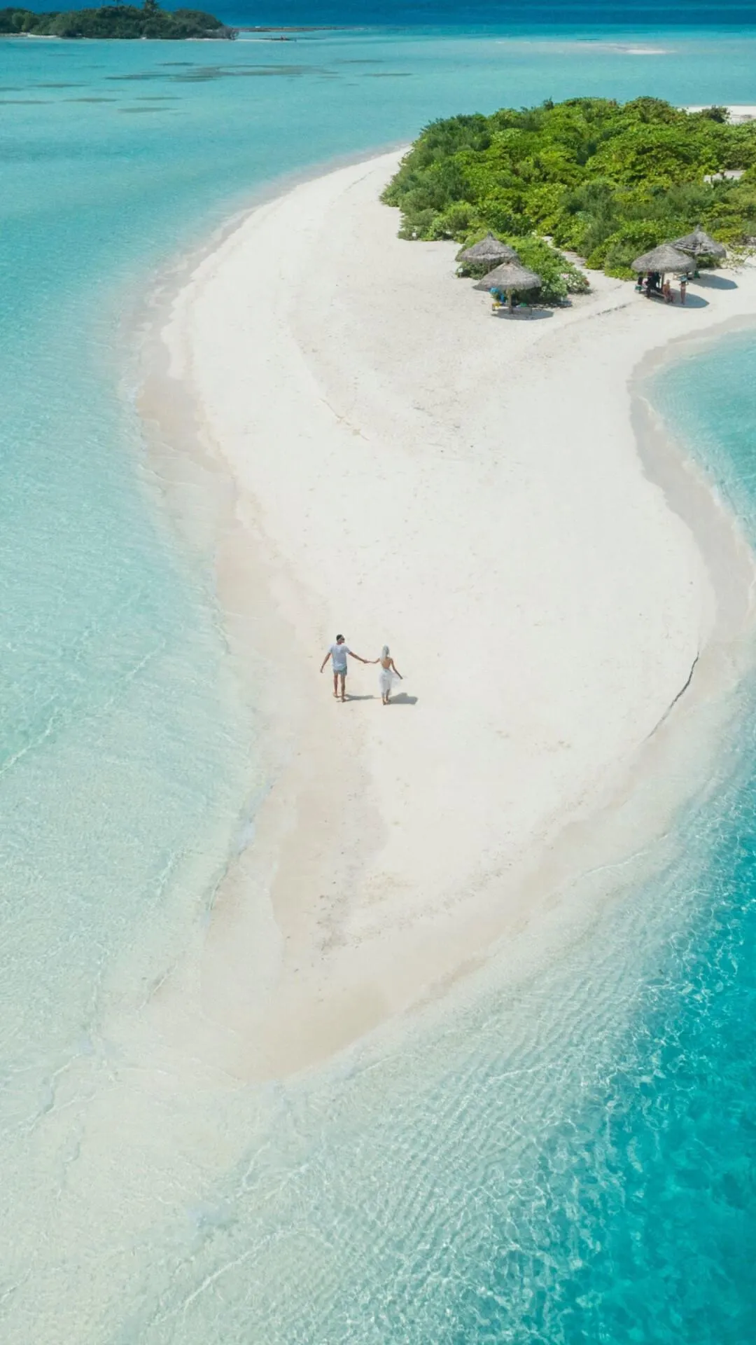 Aerial View of a White Sandy Island with Two People Walking