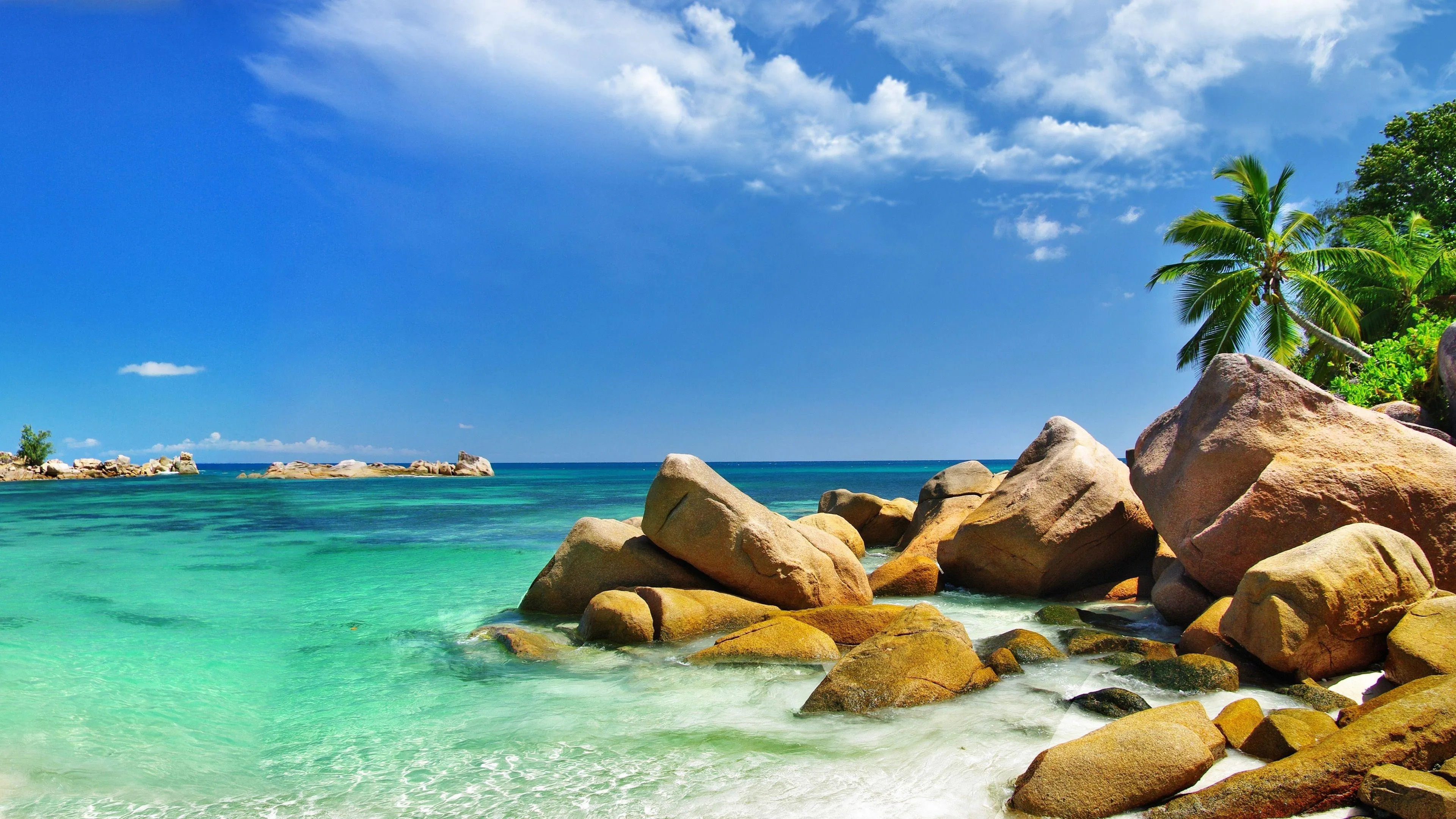 Beach Rocks and Calm Waves Under Blue Sky Free HD Wallpaper