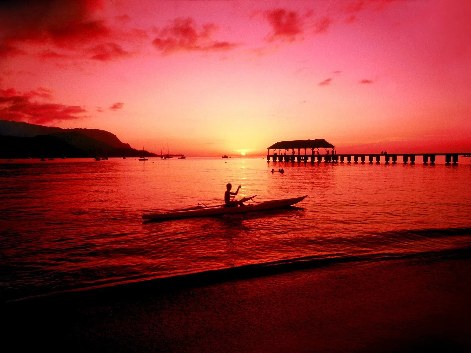 Beautiful Red Sunset over Ocean with a Boat in the Distance