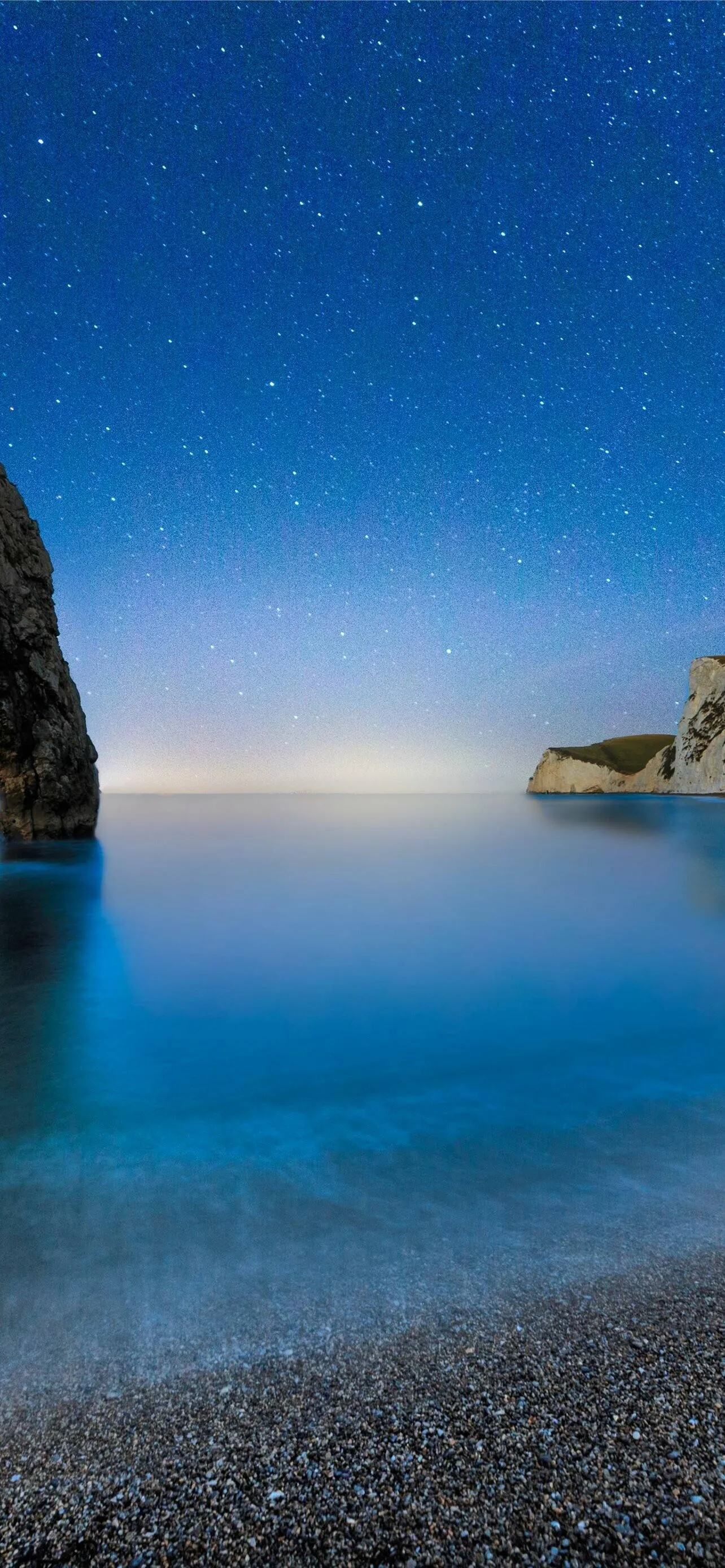 Blue Water at Rocky Beach Under Soft Morning Light Glow