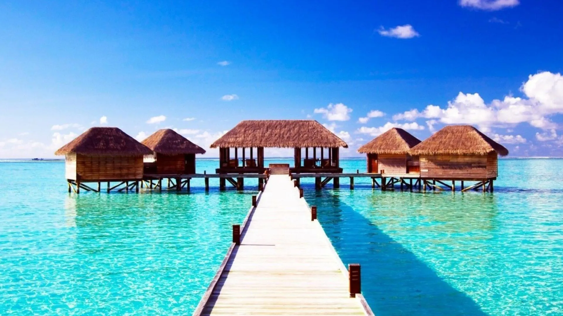 Boardwalk over Water Leading to Villas Under a Sunny Sky