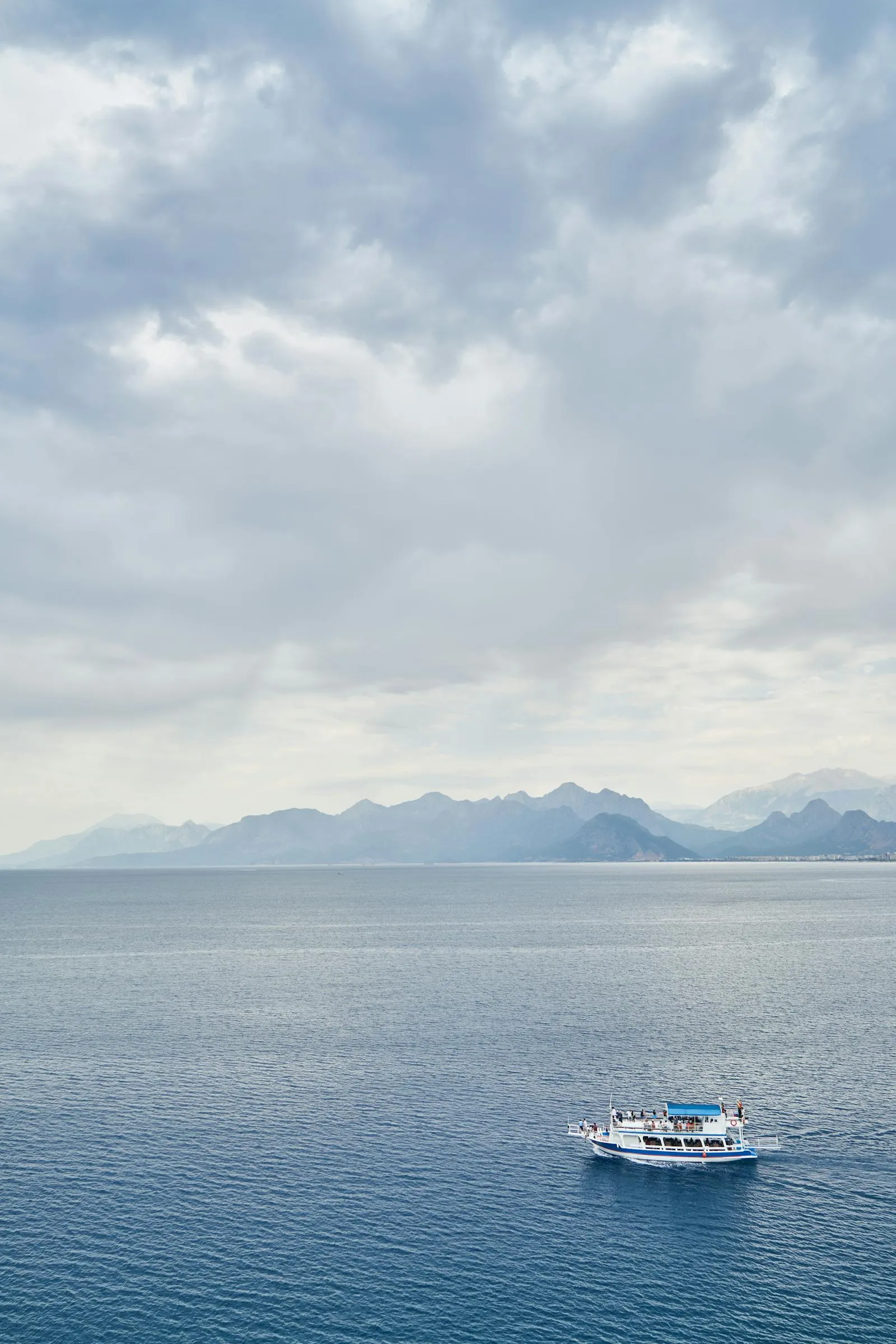Boat Floating on a Calm Ocean with a Cloudy Sky Wallpaper