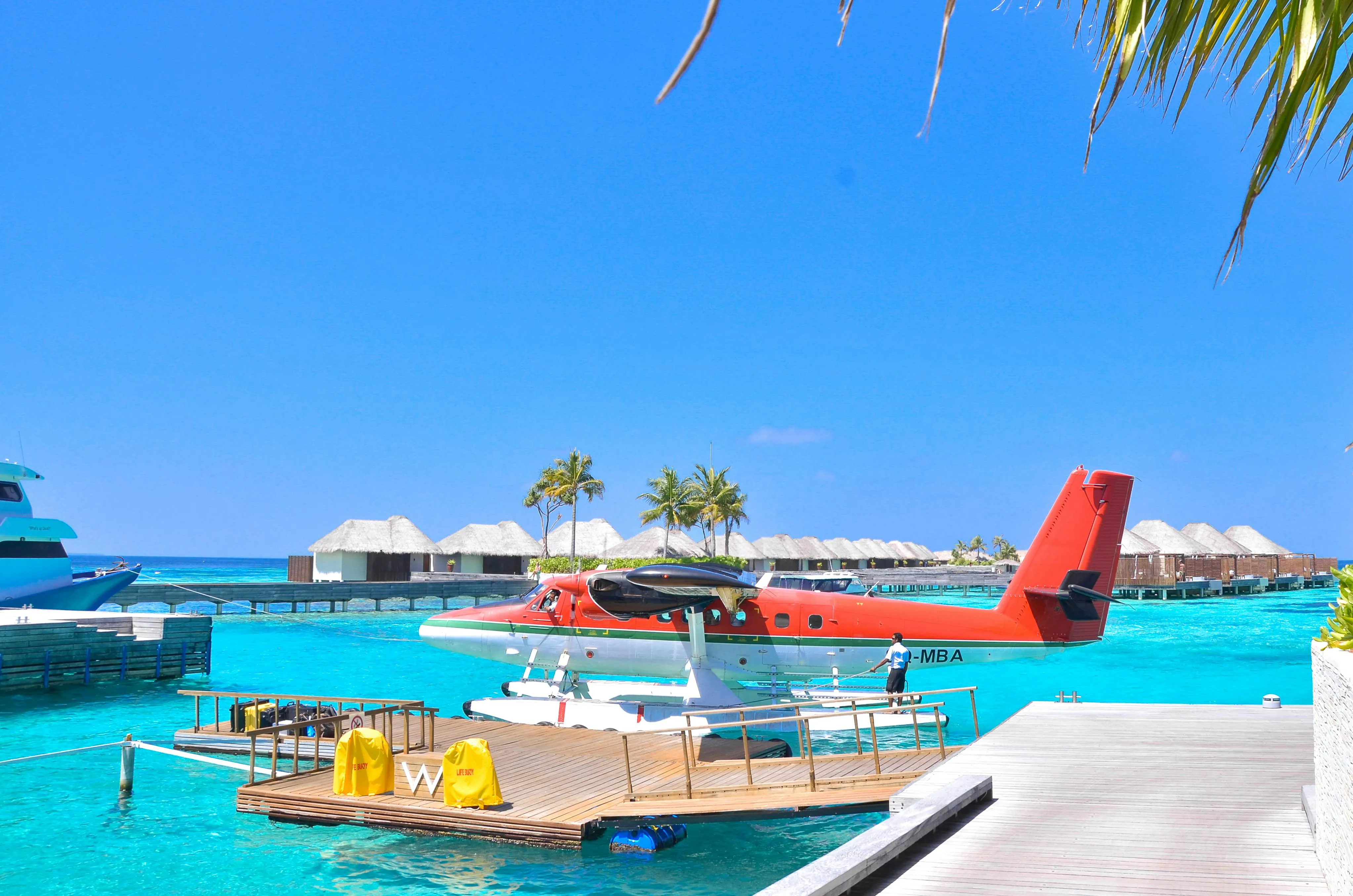 Bright Red Seaplane Docked Beside a Tropical Island