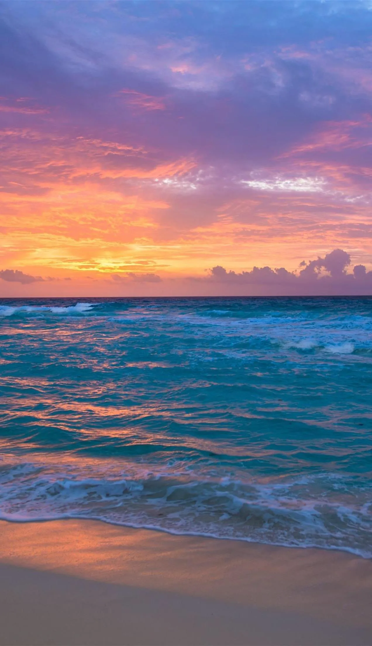 Calm Ocean Waves Under a Vibrant Sunset Sky at a Quiet Beach